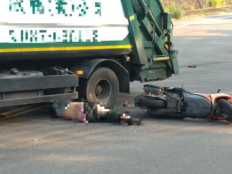 蔡姓騎士撞上垃圾車，上半身卡在車底，險遭輾過。（讀者提供）