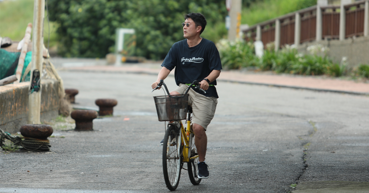 永田英洋在彰化的王功漁港騎著自行車到處晃盪，想著要是有台重機多好。