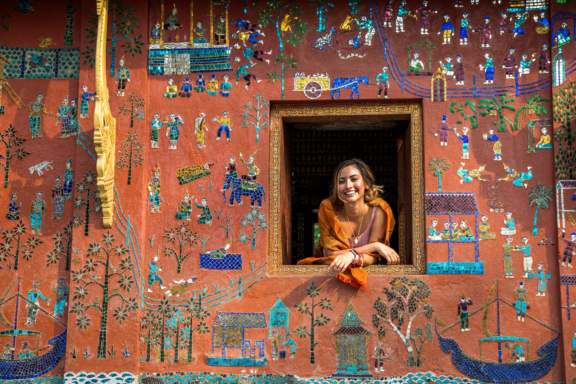 臥佛殿的窗，是許多人喜歡拍照的地點。牆上有象、馬及河流，是一幅令人嚮往的寮人生活。