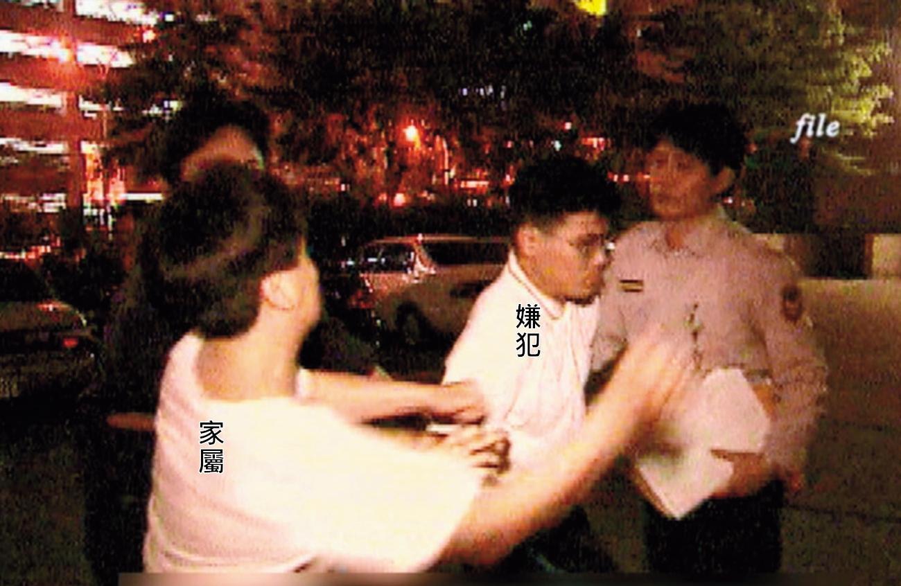 狠心殺害小姊妹的陳昆明被警方移送時,遭家屬揮拳教訓。(東森新聞提供)
