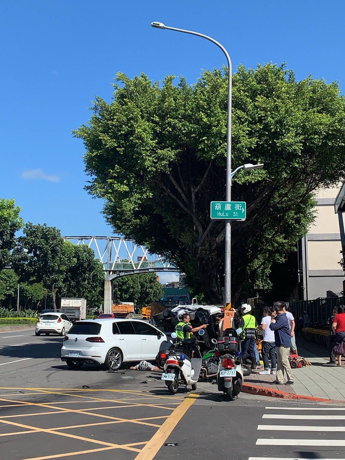 白色轎車在環河北路先撞重機後,再攔腰撞上白色休旅車,休旅車翻覆90度,波及一旁YOUBIKE。(翻攝畫面)