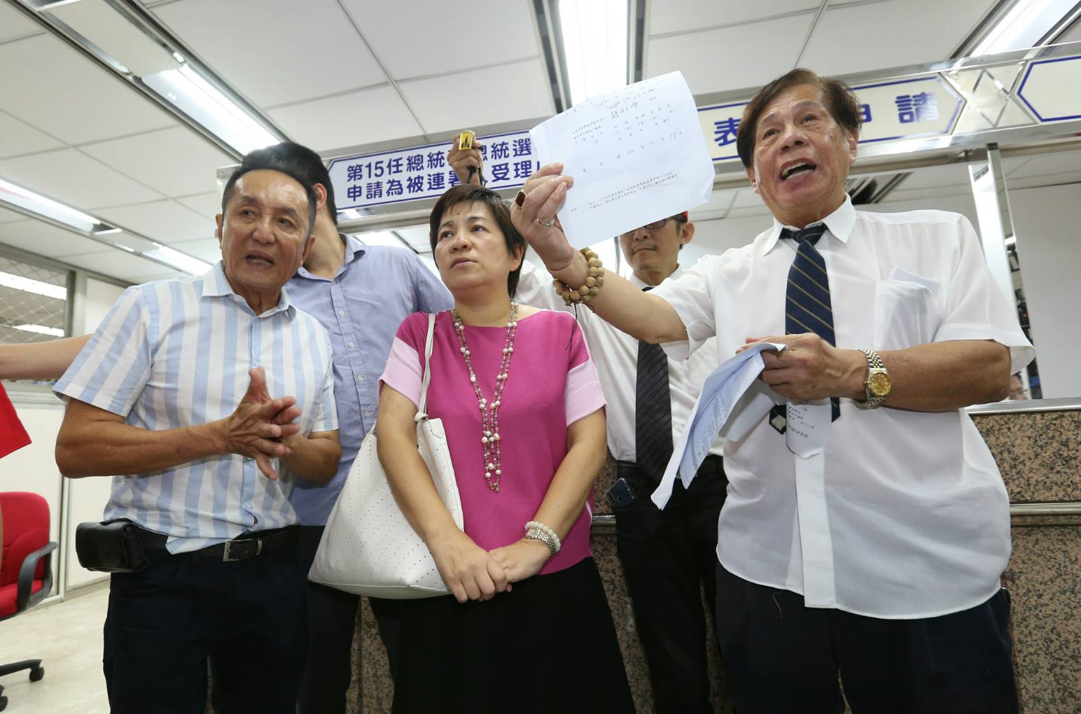 國師團更派出擁柯的前立委黃文玲（中）在中選會現場幫柯文哲領表。