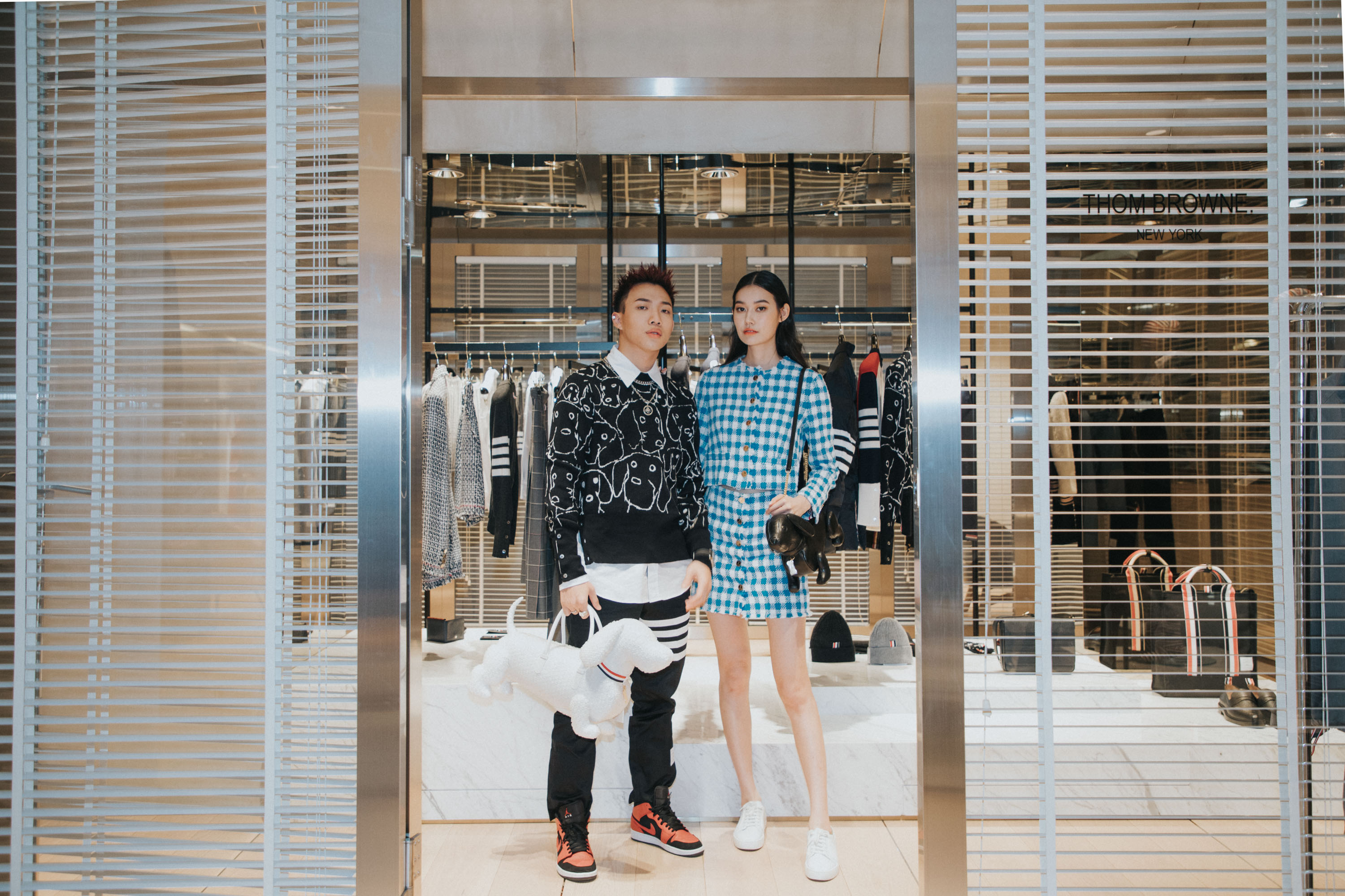 ØZI與董若彤為THOM BROWNE期間限定店開幕站台，愛狗的兩人都提著品牌經典的狗狗手提包。ØZI：THOM BROWNE 經典襯衫 $24,980、臘腸狗圖案圓領針織毛衣 $43,980 、紳士黑褲 $20,980、氣泡狗狗手提包 $66,980 董若彤：THOM BROWNE 經典藍格紋洋裝 $92,980、THOM BROWNE 狗狗手提包 $72,980。（ART HAUS提供）