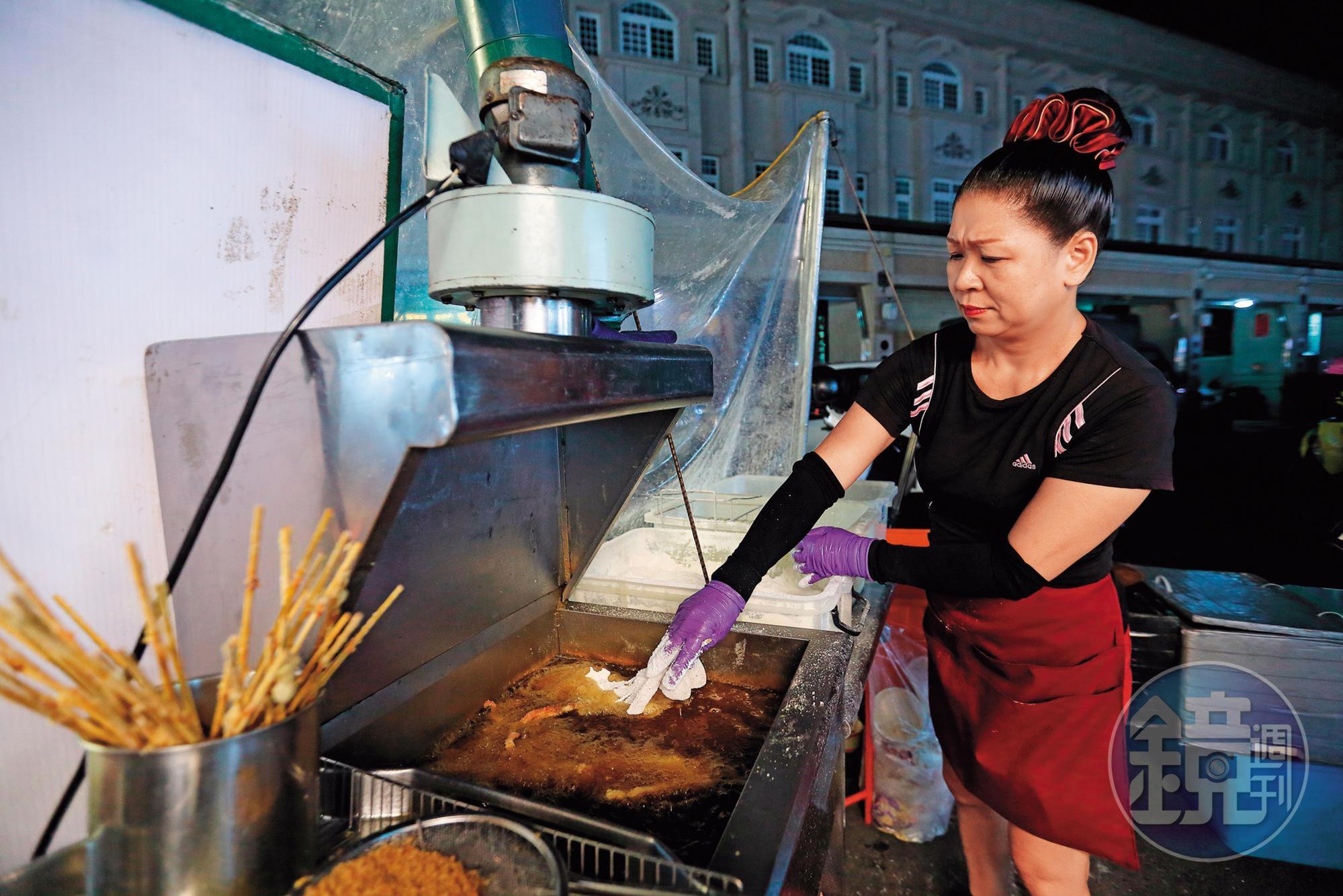 魷魚本身含水份，遇高溫油鍋難免噴濺，即使是炸物老手，許晏庭仍小心翼翼地操作。
