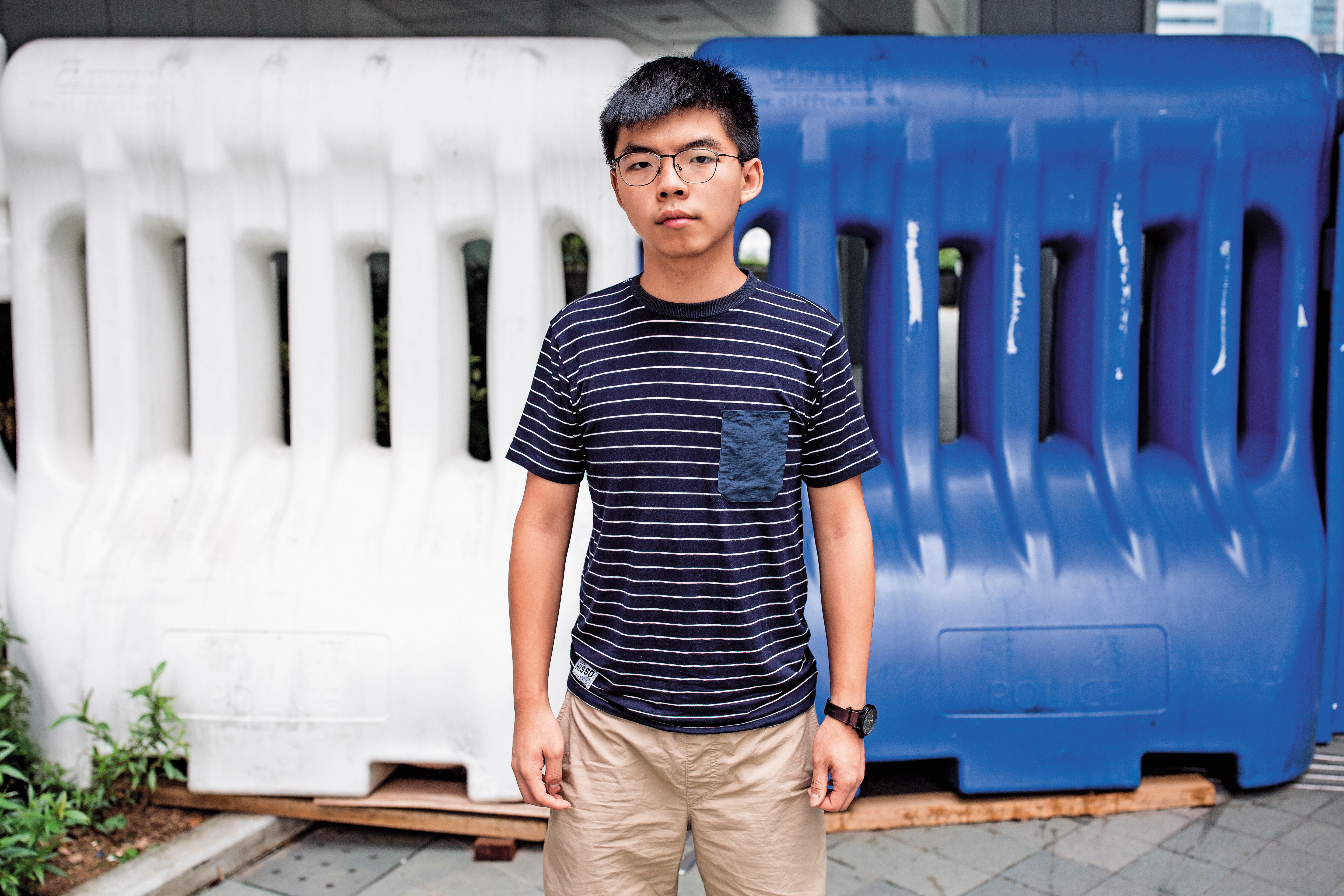 黃之鋒特意選在香港總部旁受訪，拍照就站在總部大門，毫無懼色。