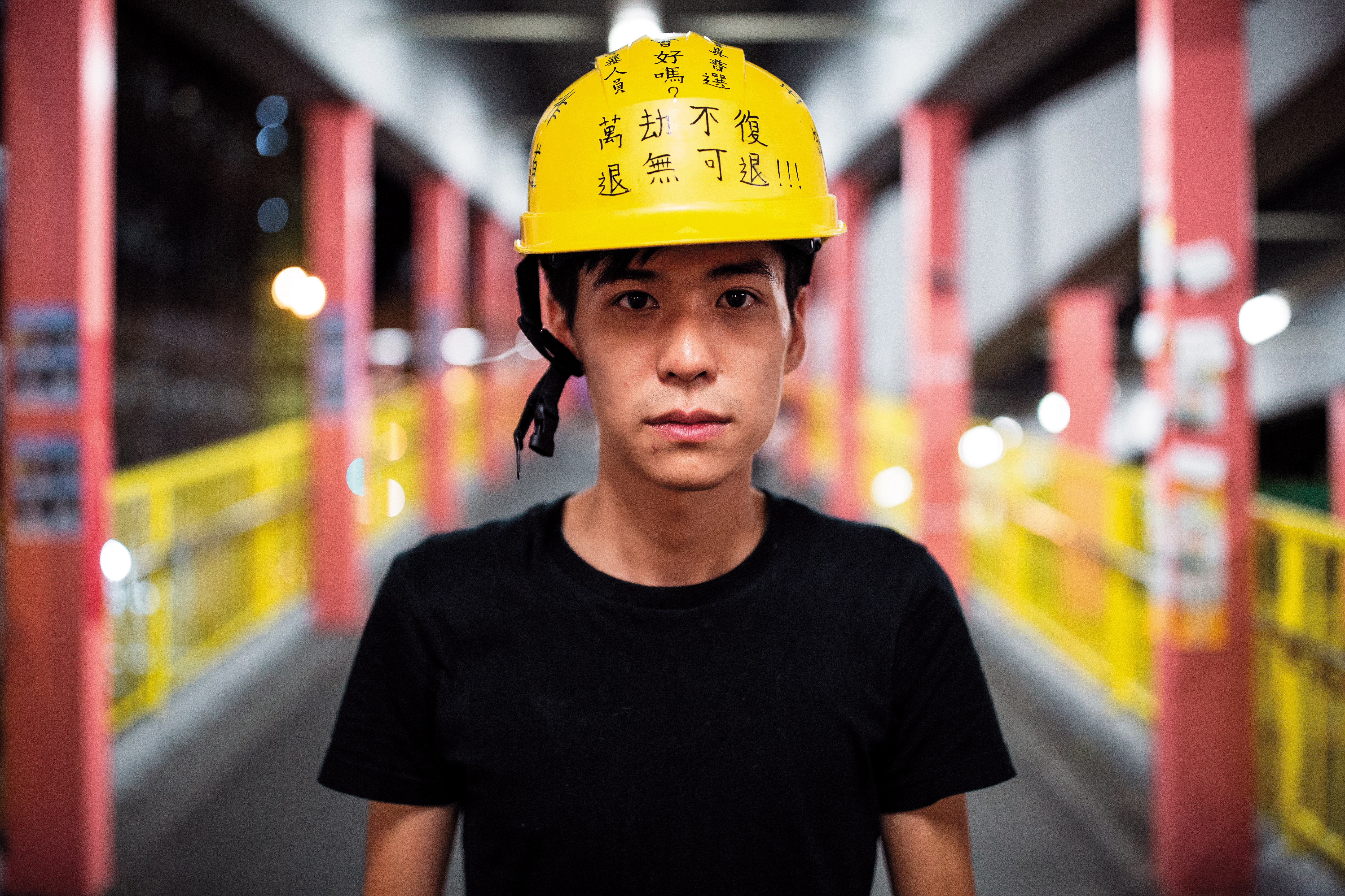 葵芳地鐵站因日前有鎮暴警察衝進濫射催淚彈，訪問這天，岑敖暉站在地鐵站拍照，頭上安全帽寫著五大訴求。