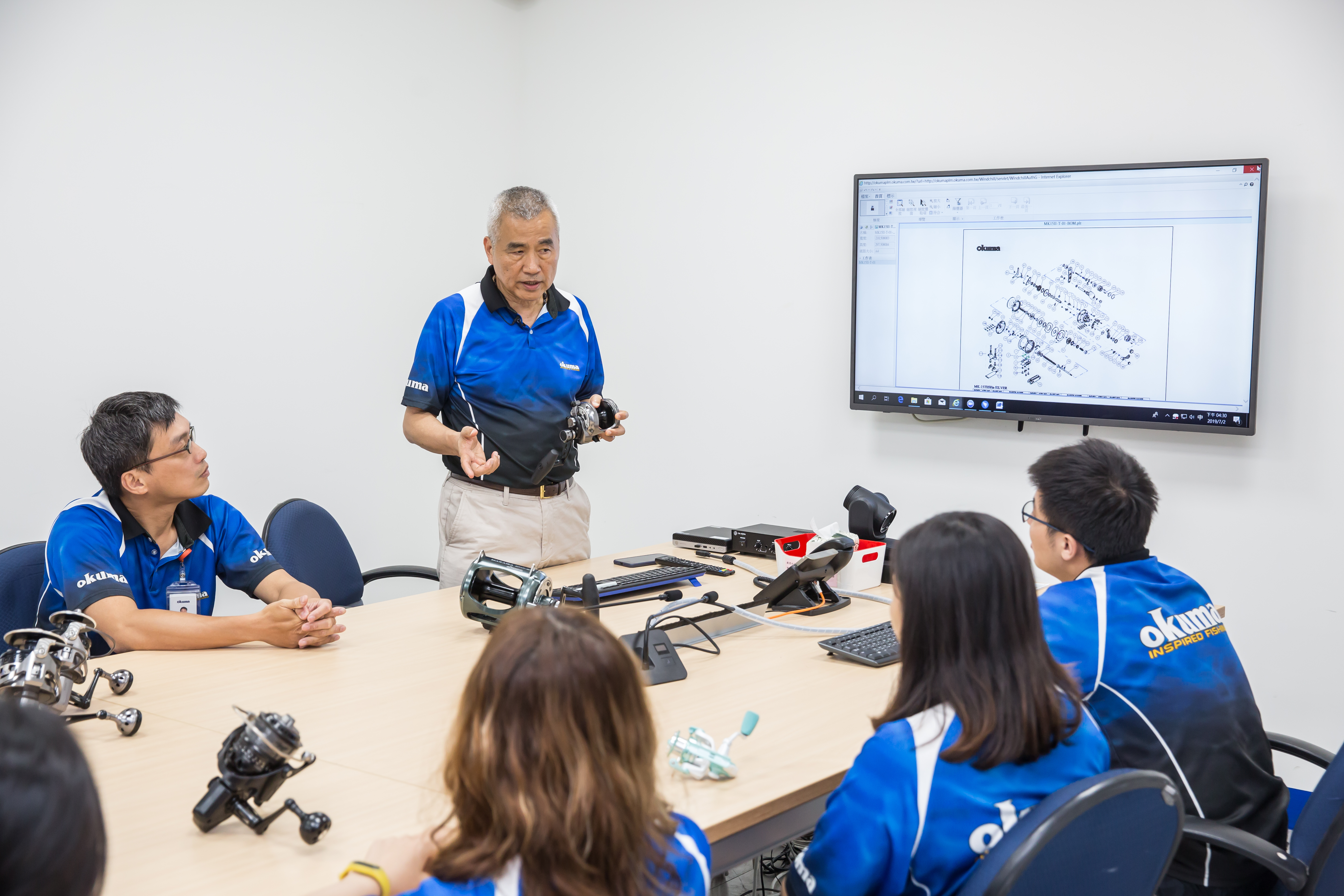 張良任（站立者）注重細節，每一款指標捲線器從設計到開發，他堅持全程參與。