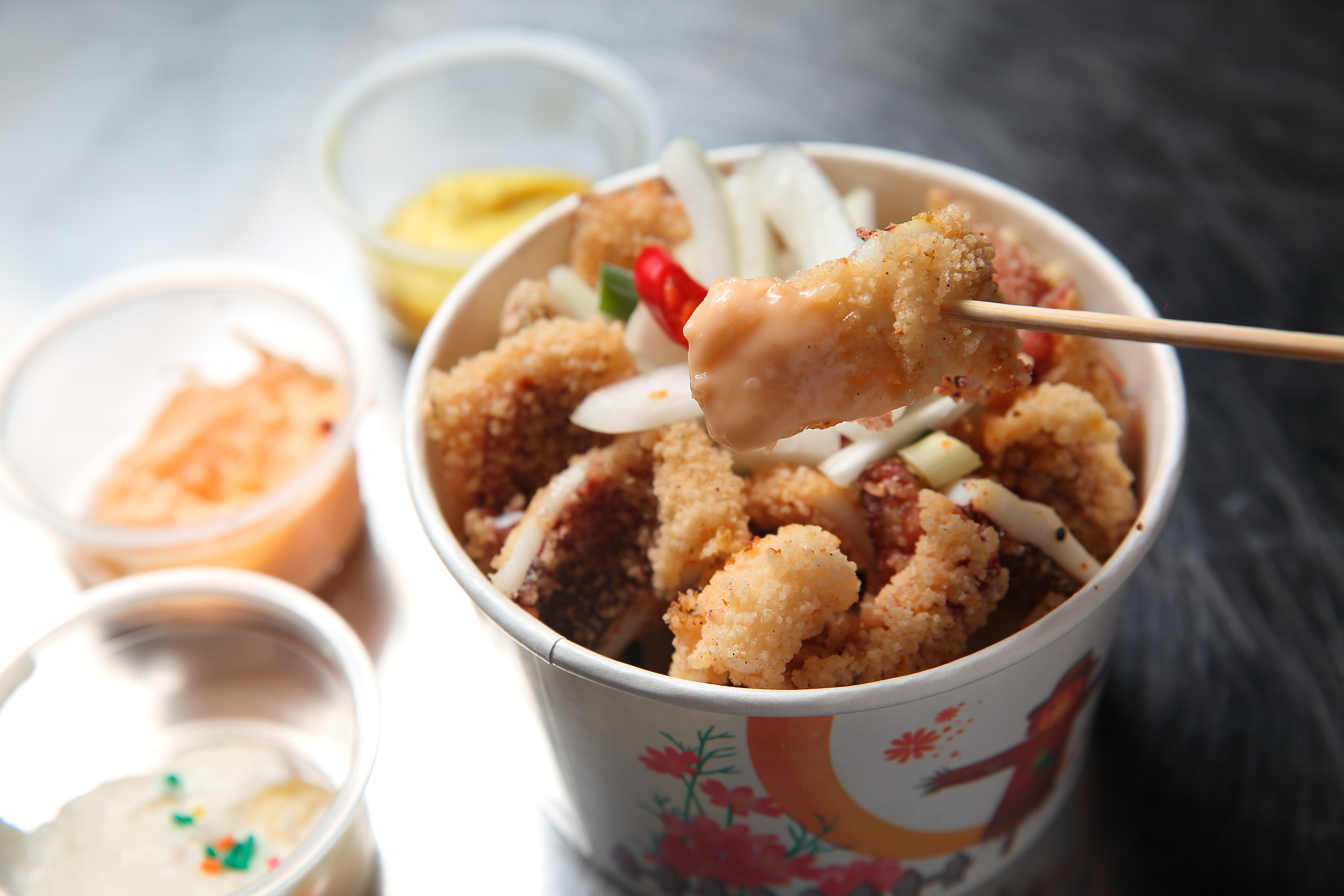 沾上泰式沙拉醬的酥炸大魷魚，別有一番風味。（中份100元）