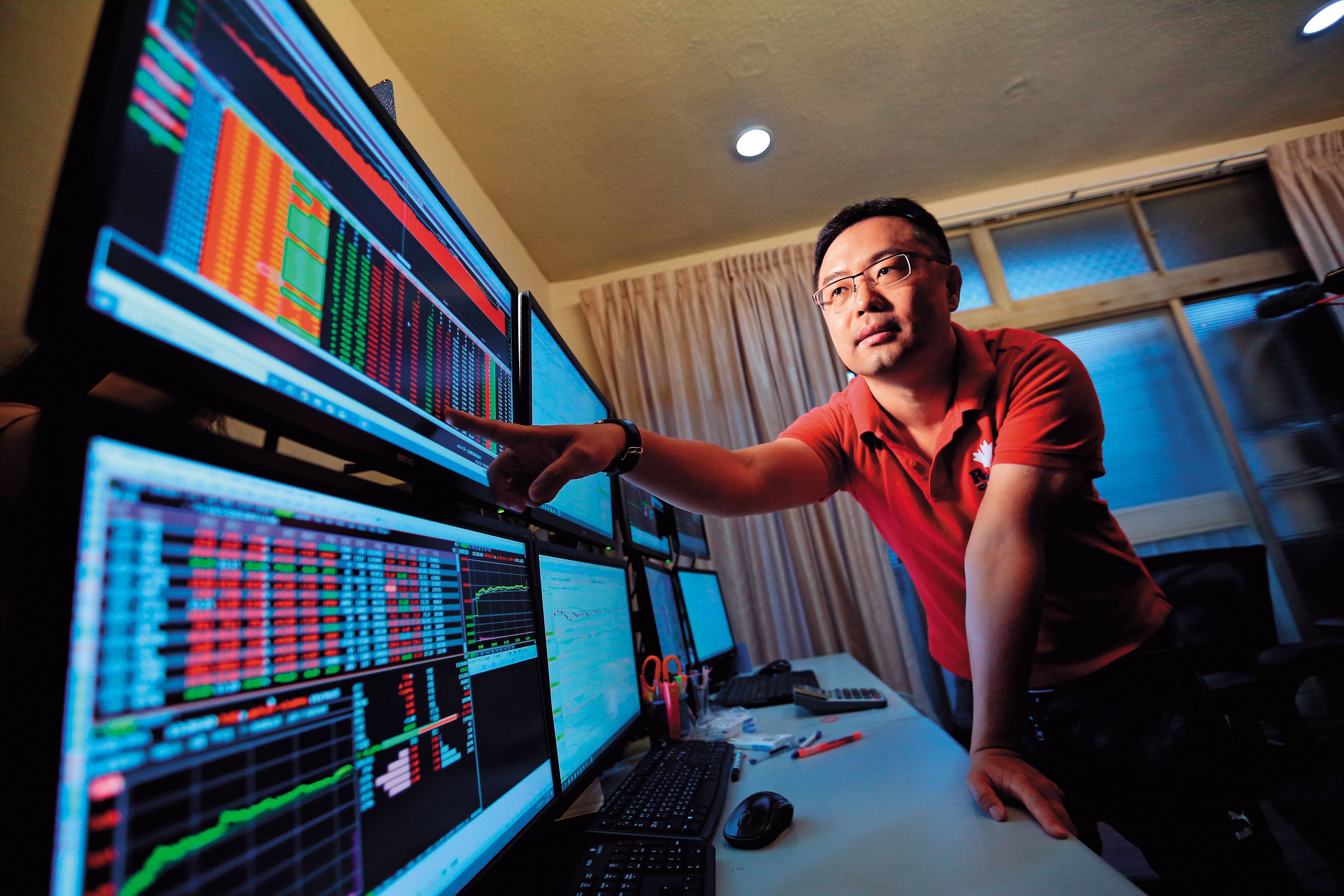 看盤室中，8台電腦螢幕一字排開，戴成霖天天觀察股價變動，每年從股市中提款百萬元。