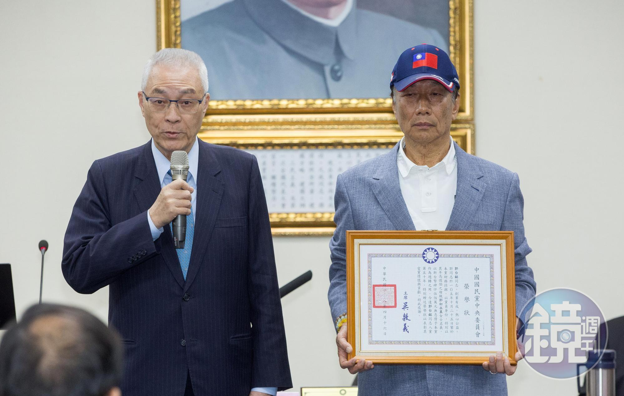 鴻海集團創辦人郭台銘（右）日前宣布退出國民黨，現被慰留。圖為4月郭台銘獲頒榮譽狀。