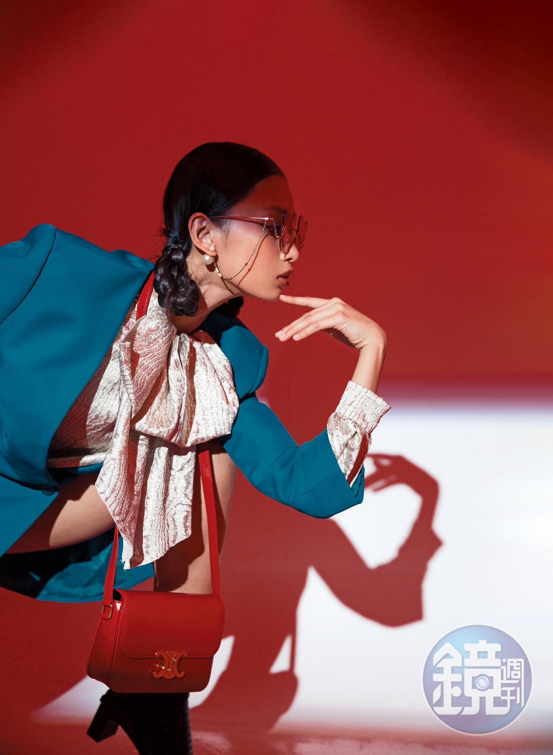 TRIOMPHE鮮紅色光滑小牛皮肩背包，NT$135,000 by CELINE／西裝洋裝，NT$64,600 by BALENCIAGA／淺銀色長袖襯衫，NT$61,300 by GUCCI／黑色短靴，價格未定 by BALENCIAGA／泰迪熊系列荆棘玫色墨鏡，NT$7,280 by FOR ART'S SAKE／Tribales仿舊金屬珍珠耳飾，NT$15,500 by Dior