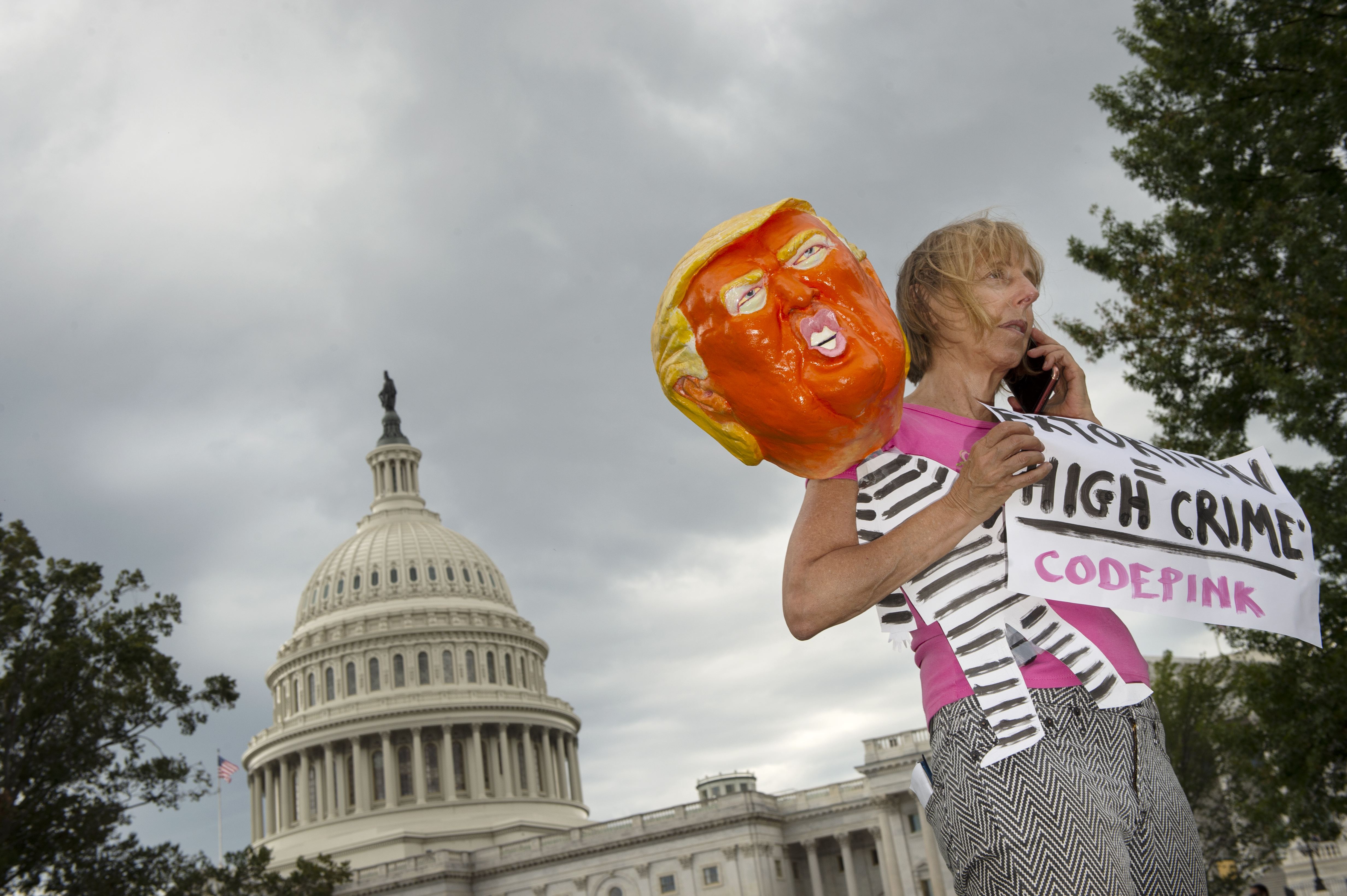 2019年9月26日，反川普的抗議人士拿著穿囚服的川普人偶在美國國會山莊外呼籲國會彈劾川普。（東方IC）