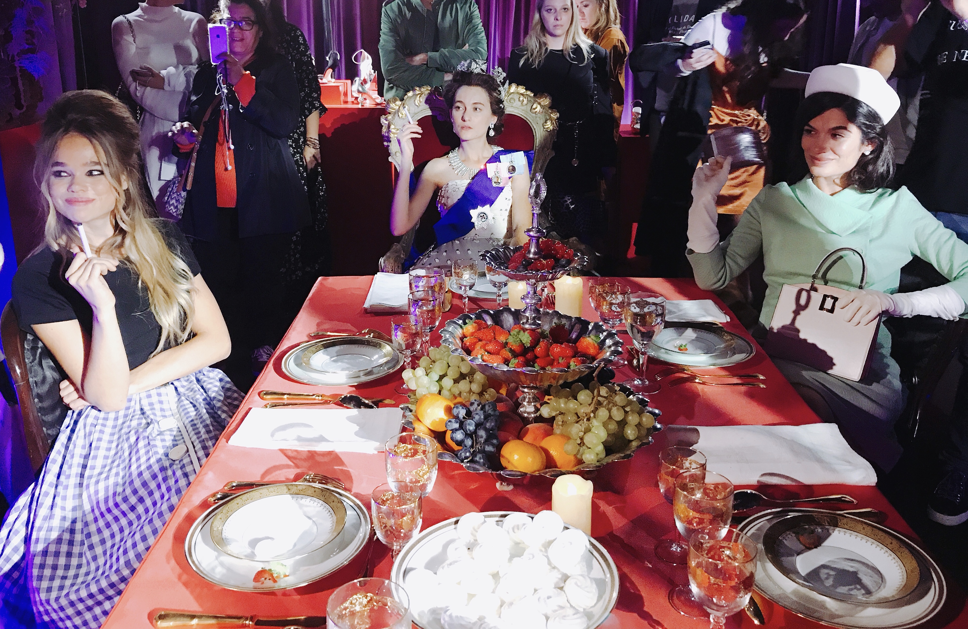 在一間密室內，可見到英國女皇、賈桂琳甘迺迪與碧姬芭杜，一同在餐桌上欣賞表演。