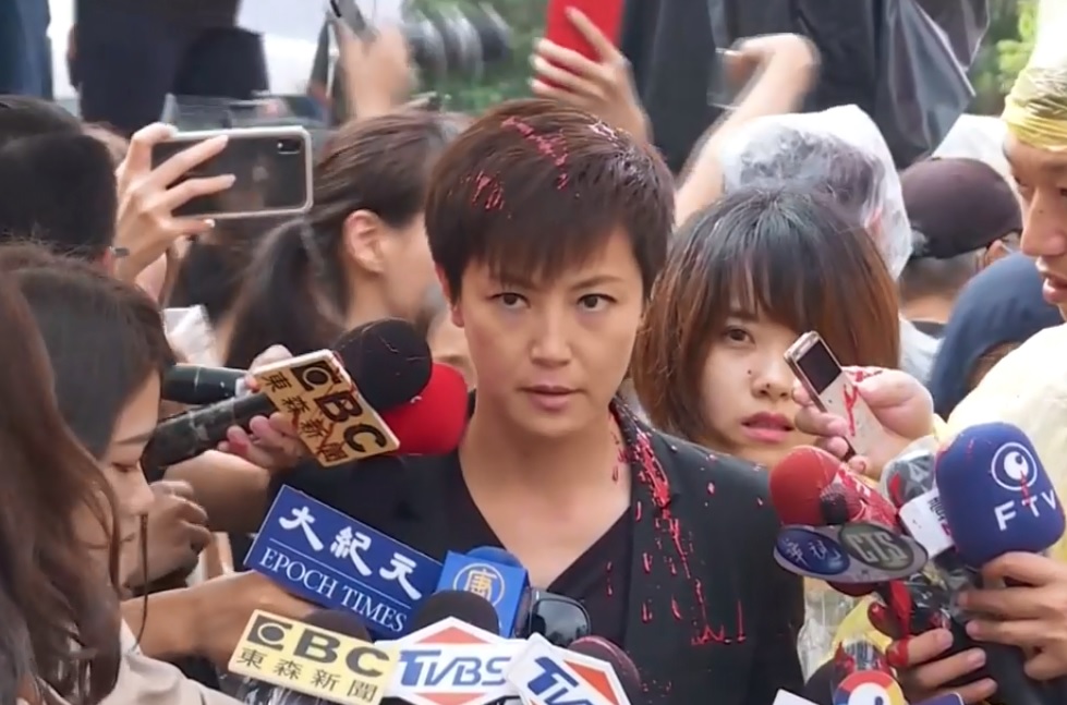 香港歌手何韻詩接受媒體聯訪時，突然被一名蒙面男子潑漆。（翻攝自新唐人亞太電視台臉書）