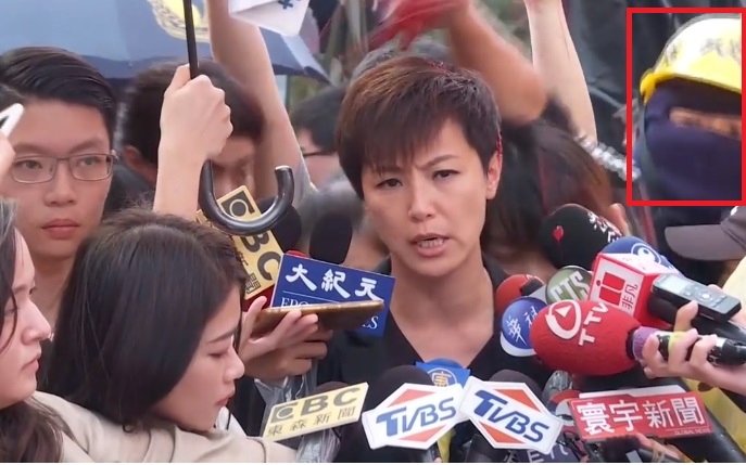 何韻詩在接受媒體採訪時，遭到蒙面男子潑灑紅色油漆。（翻攝自新唐人亞太電視台臉書）