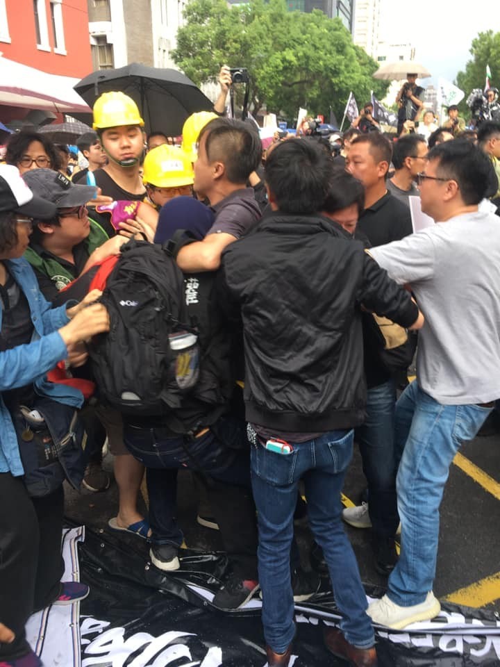 胡嫌滋事後,被參與遊行的民眾壓制。(翻攝畫面)
