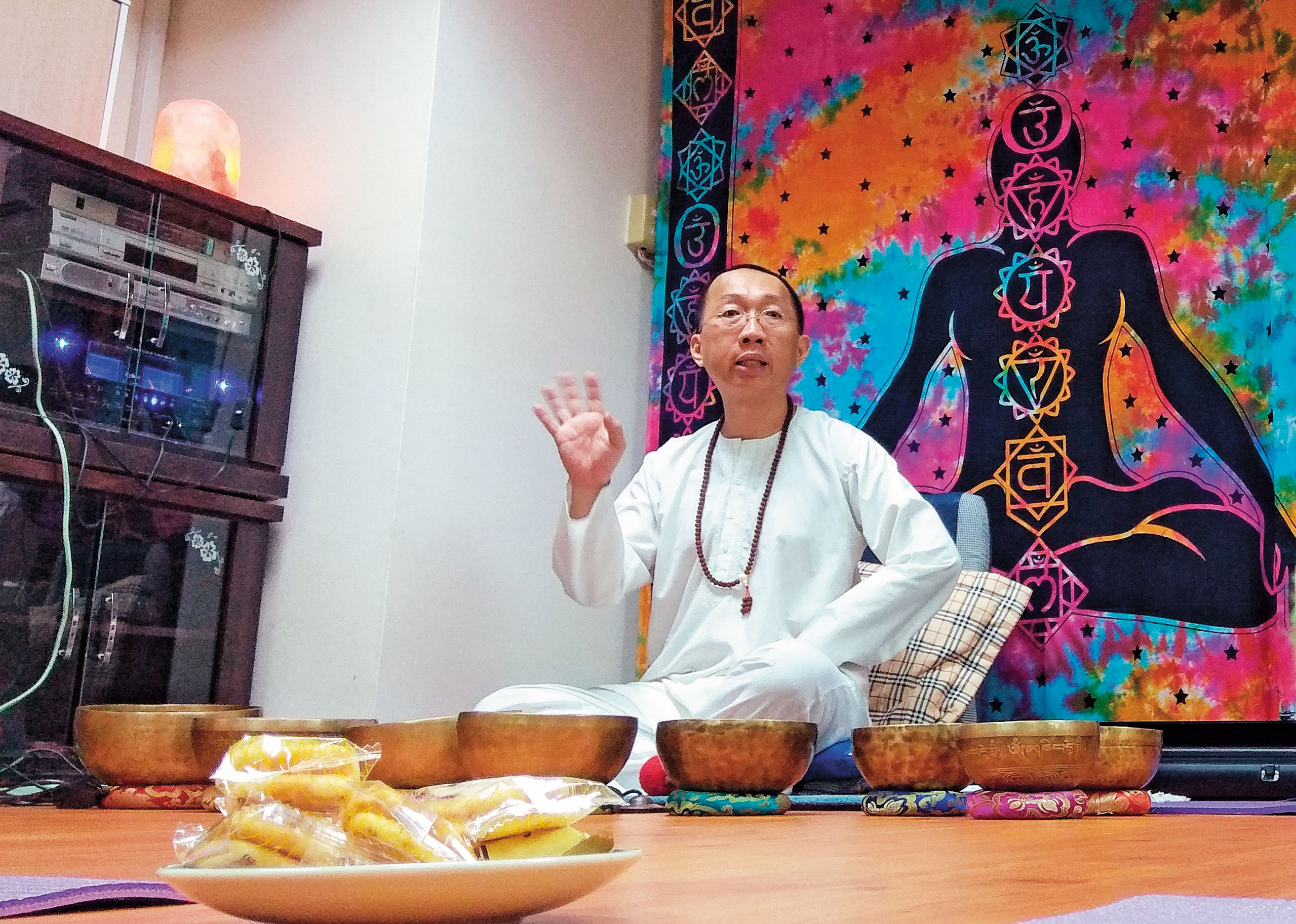 自稱能量大師的許台融端坐頌缽後，向學員講解疾病產生原理。