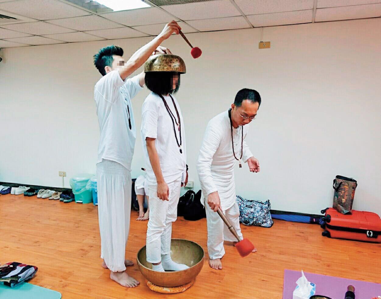 許台融(右)將大缽放在學員頭頂與腳下敲擊,聲稱發出的音波能療癒疾病。(翻攝臉書)