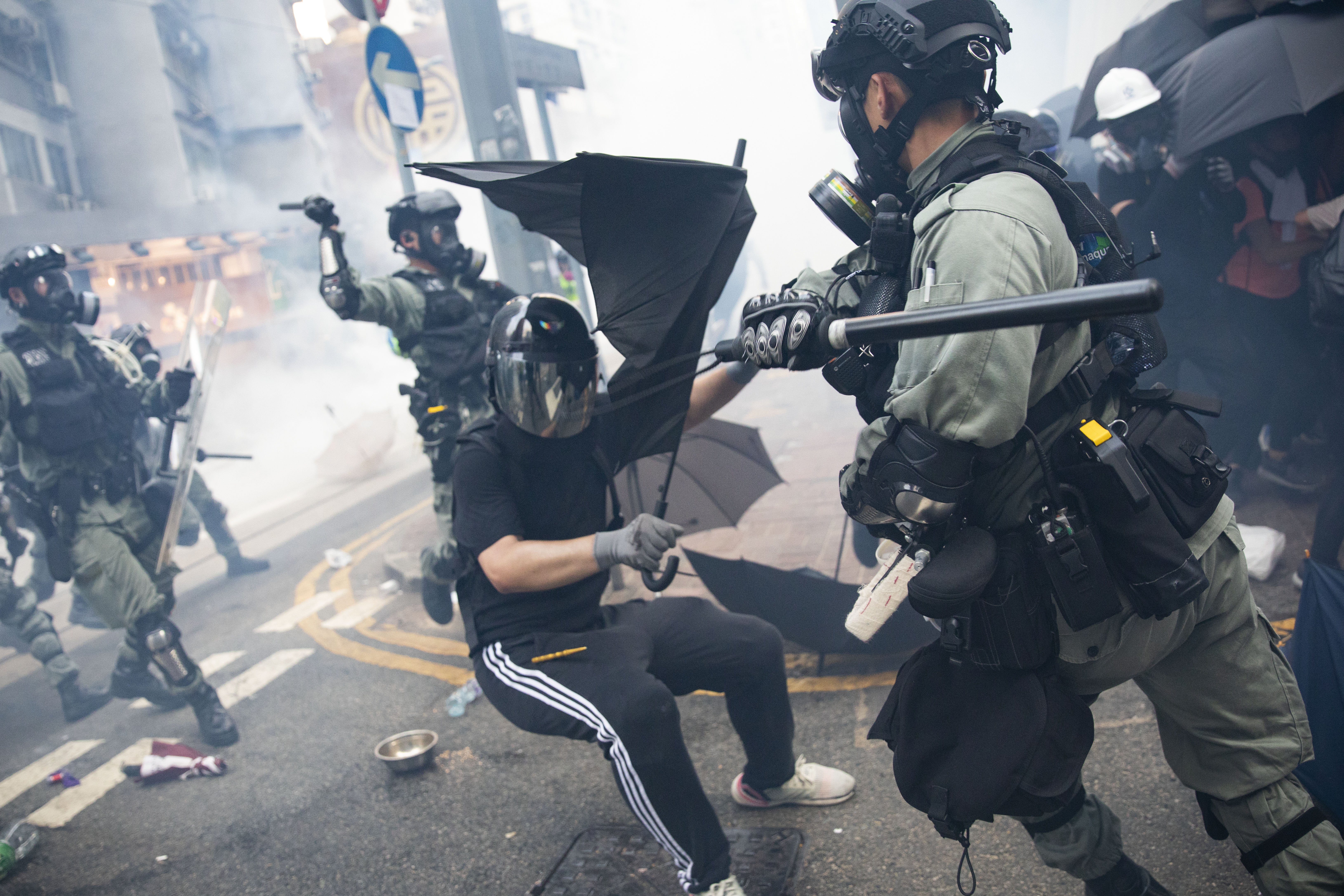 一名抗爭者在灣仔街頭以雨傘抵抗警長的棍棒槍砲。