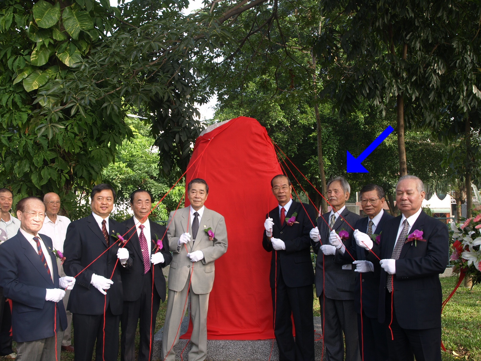 現年97歲的楊馥成（右三、藍箭頭者）與林余立、許華杞控告日本政府，要求承認其仍具日本國籍。圖為楊馥成去年為恩師捐贈石碑的揭碑儀式。（翻攝自嘉大校訊）