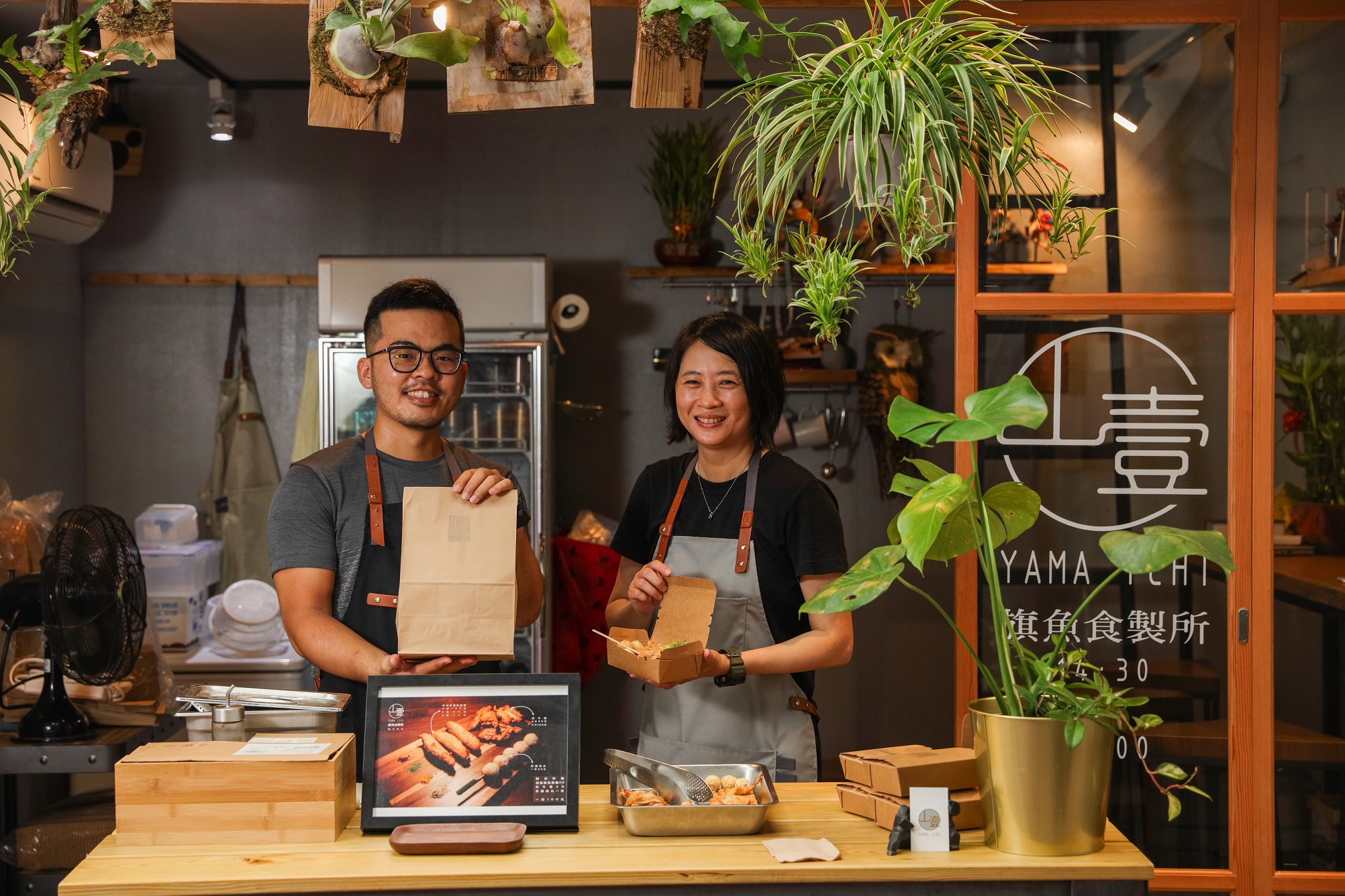 欣珊（右）與老公（左）一起經營「山壹旗魚食製所」，打造出不同於市場傳統攤位的小店。