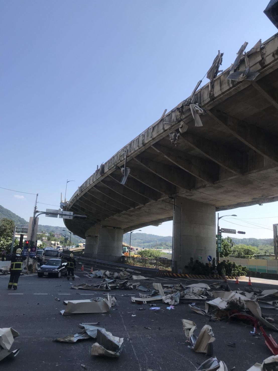 大量遭撞毀的護欄鐵皮則是飛墜至下方八里區商港路上,造成一名老翁受傷。(翻攝畫面)