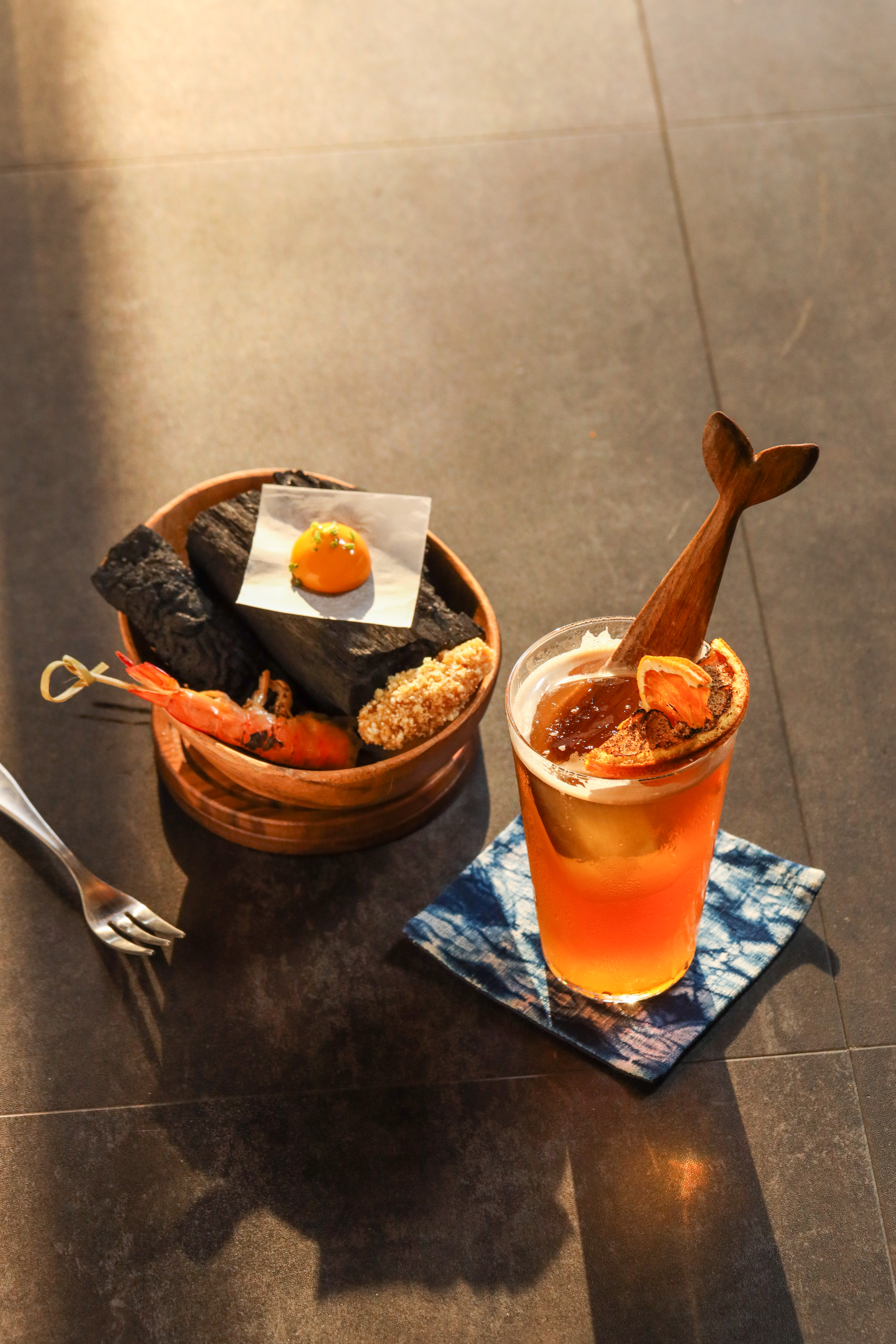 有濃厚水果風味的「湧浪」插著魚尾木匙登場，烤橙片與炭烤海鮮小食，聯想起海灘BBQ畫面。（500元／杯）