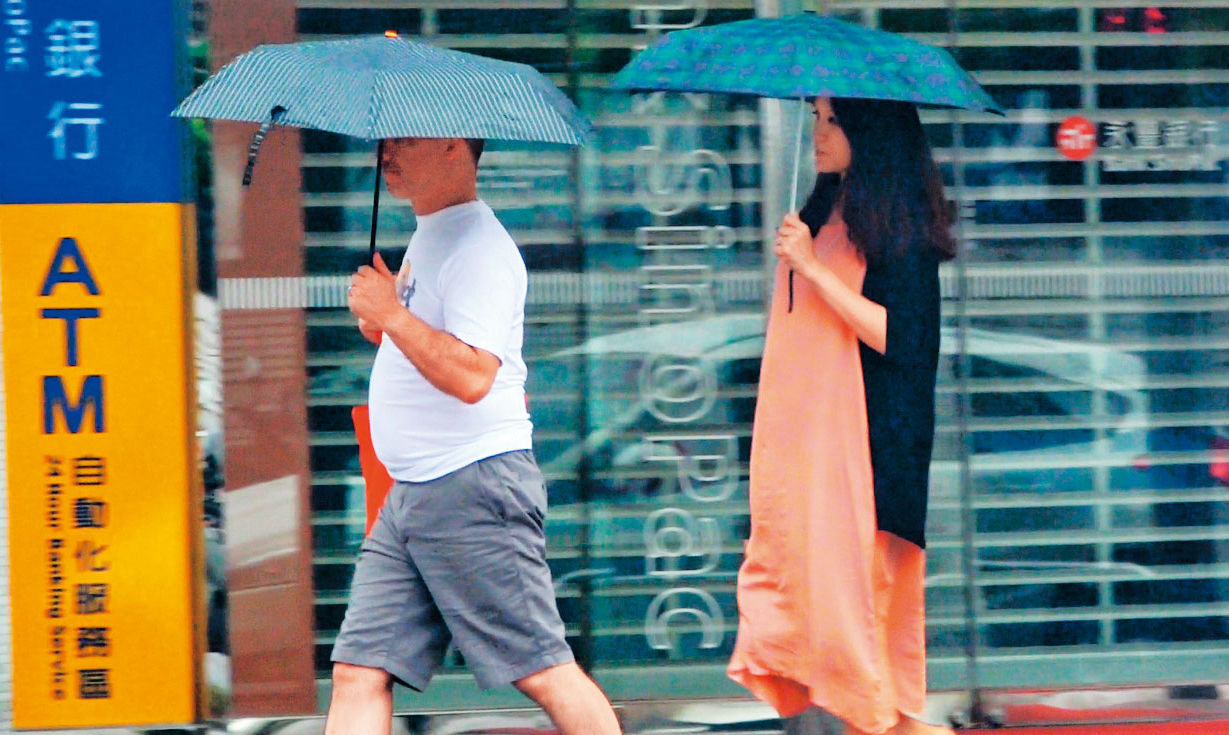 9月30日13:19，颱風停班當天，本刊直擊，採購完食物的雷明思（左）與連詠心（右）回到一品大廈，畫面可見雷明思的肚子絲毫不比即將待產的老婆遜色。