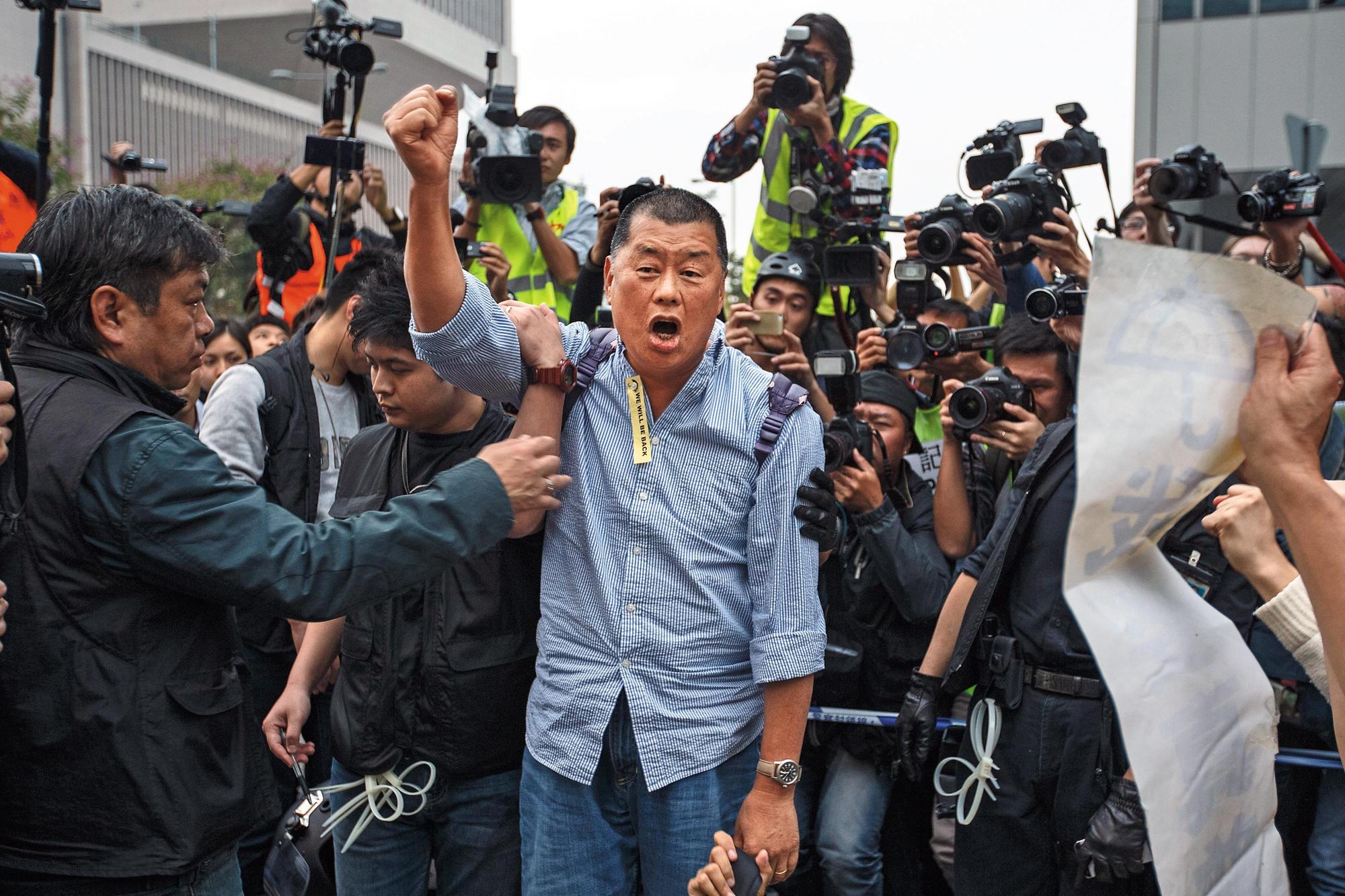 2014年12月11日，占中行動遭到警方強行清場，黎智英堅持在港島金鐘占領區內留守，當他遭警員押走時，仍高喊抗爭口號。（達志影像）