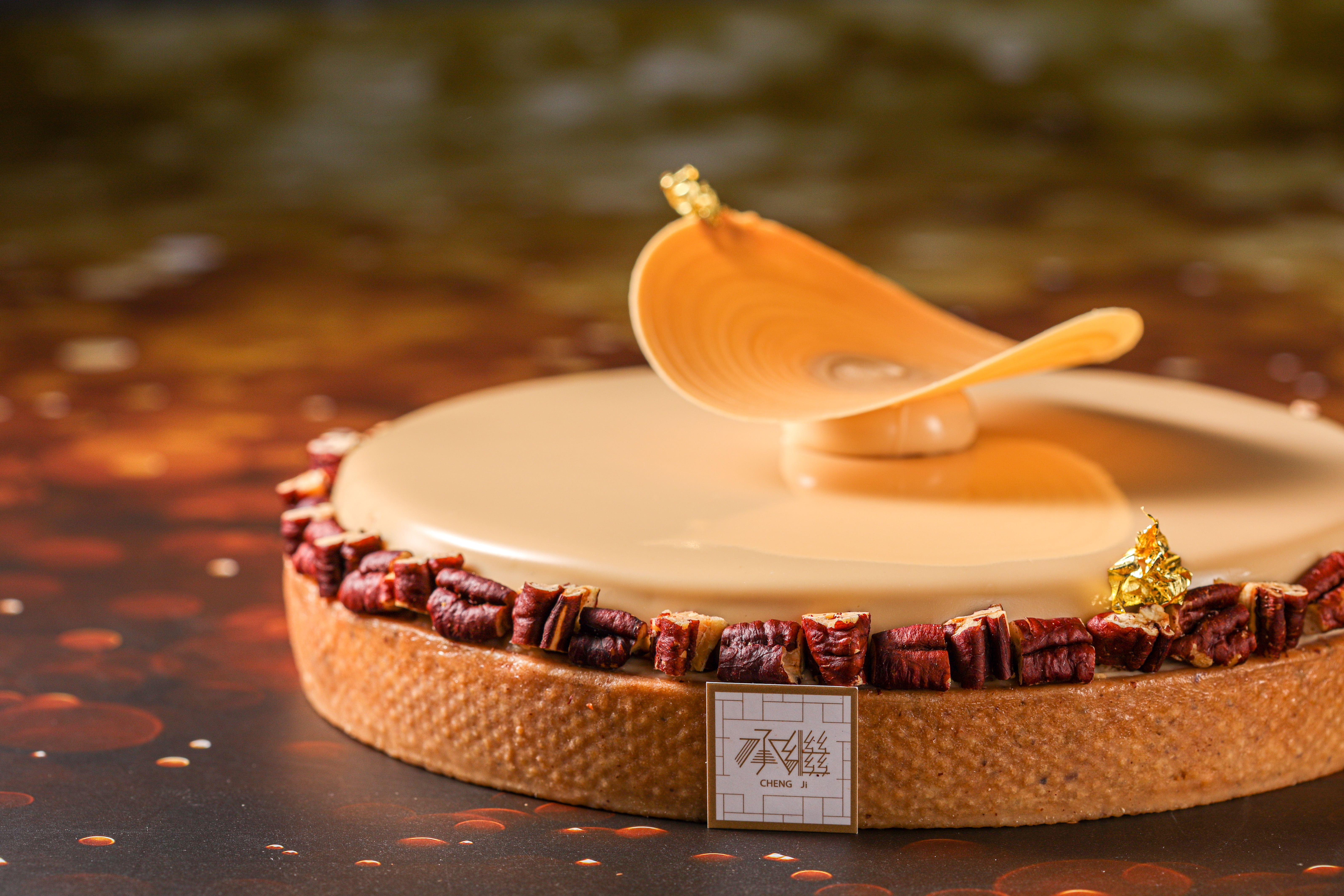 「焦糖胡桃塔」的原型是美式經典胡桃派，在焦糖太妃糖鏡面裝飾的焦糖巧克力螺旋脆片，靈感來自甜點大師Yann Brys的螺旋狀裝飾法。（1,380元／個）