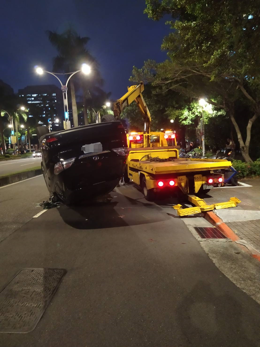 黑色休旅車疑似因為車速過快自撞安全島,「翻白肚式」大翻覆。