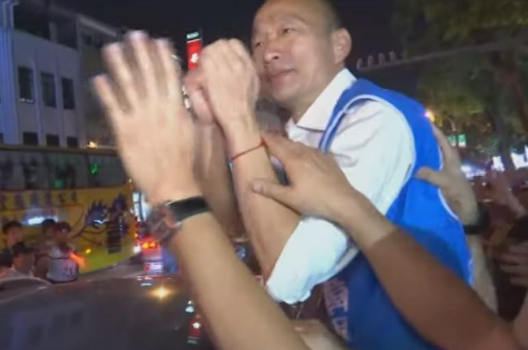 韓國瑜結束台南造勢大會離去前，遭民眾朝他丟雞蛋，但他未被砸中。（翻攝畫面）