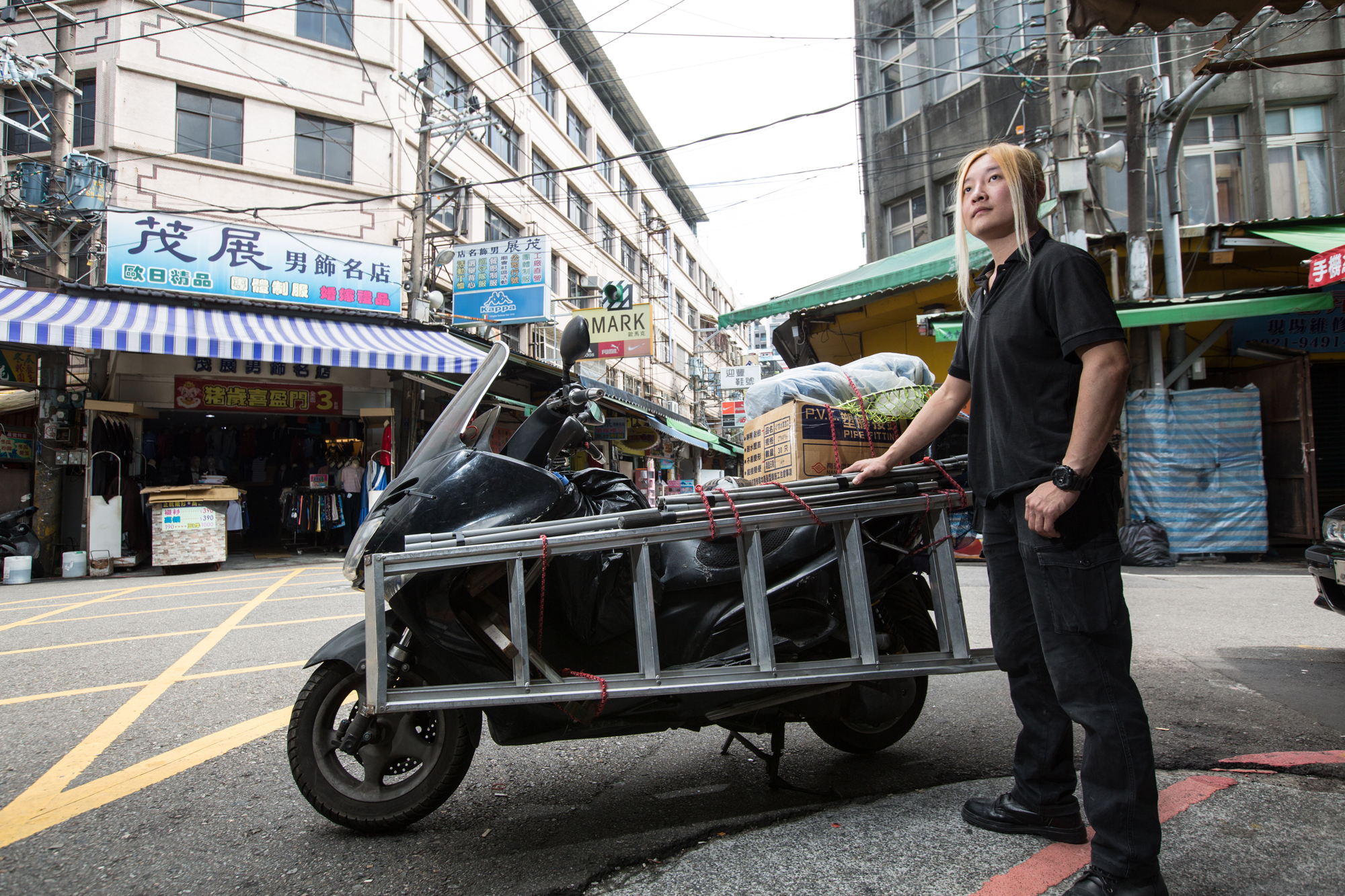 夏冠群平日修水電、救貓，騎著的是十多年前買來的二手重型機車，為了防雨，工具、材料與救貓設備都用塑膠袋包著。