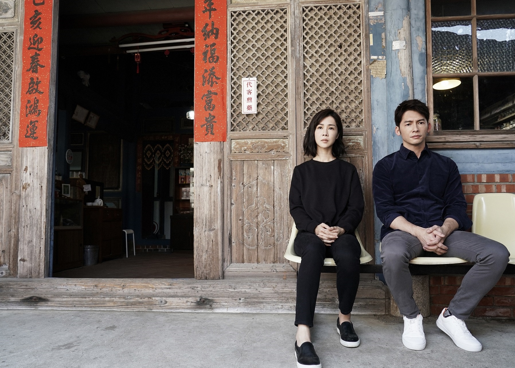 《俗》劇主角謝盈萱（左）與溫昇豪（右）並坐在古厝門口聊天。（台南市觀光旅遊局提供）