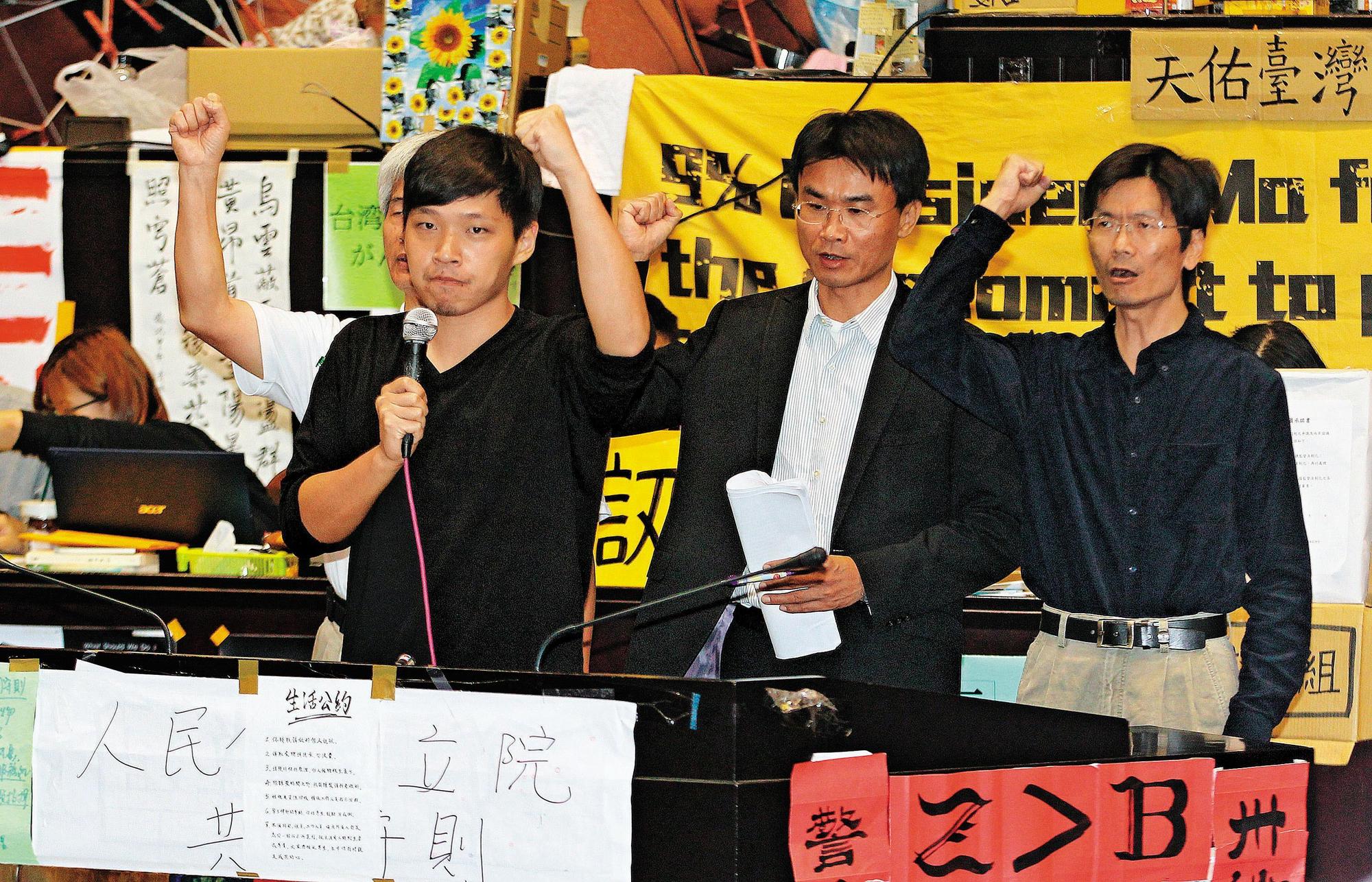 太陽花運動學生攻占立法院當晚，陳吉仲（中）是中興大學主任祕書，向學校遞了辭呈，備好牙刷、毛巾陪學生做長期抗爭。（中央社）