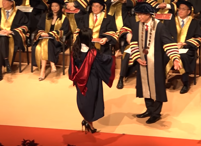 香港理工大學校長滕錦光拒絕與戴口罩的兩名女學生握手合照。（翻攝自香港電台視像新聞臉書）