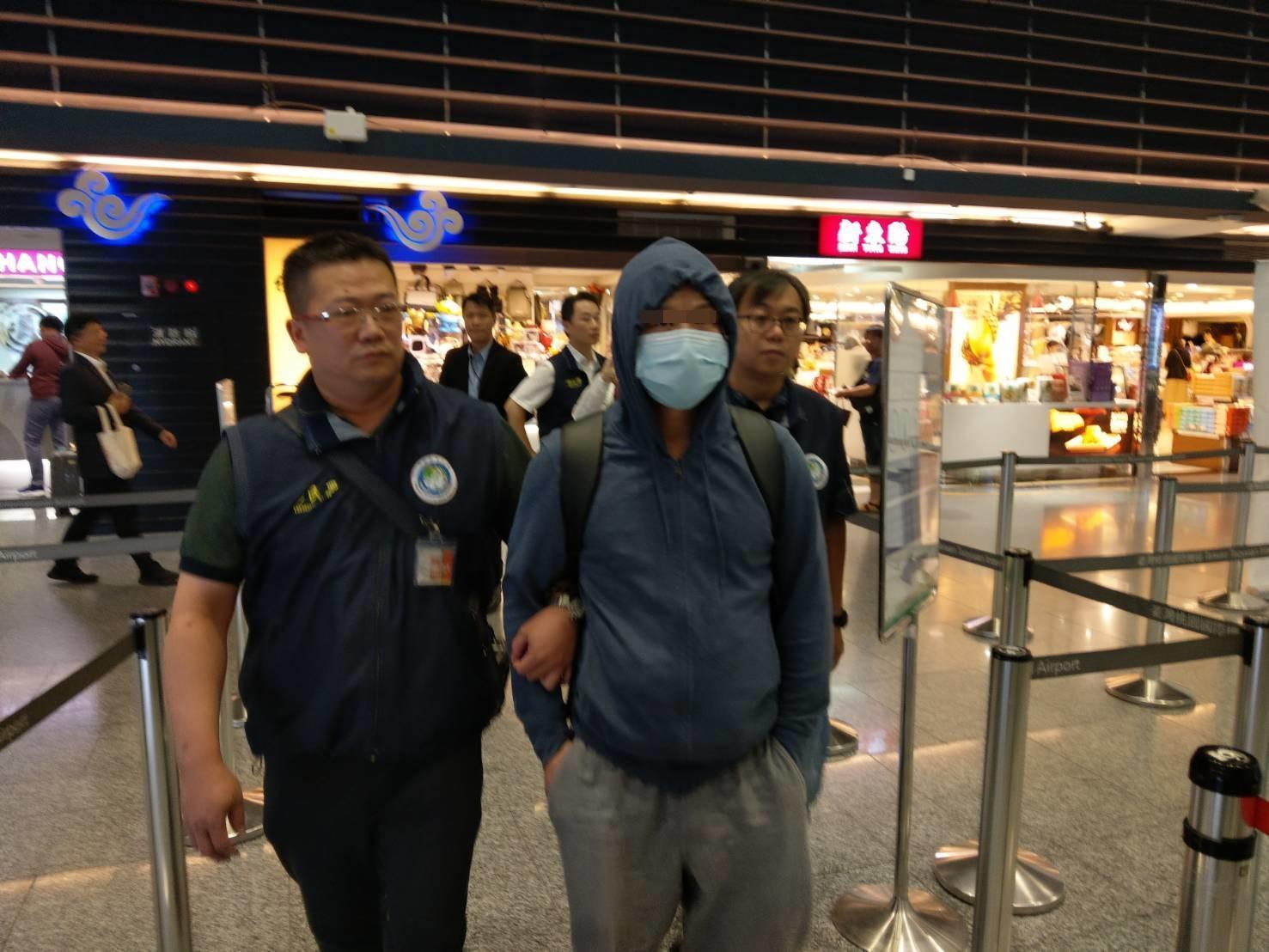 胡姓男子(戴口罩者)28日晚間遭移民署押送至機場,強制出境,並管制5年內不得再來台灣。(翻攝)
