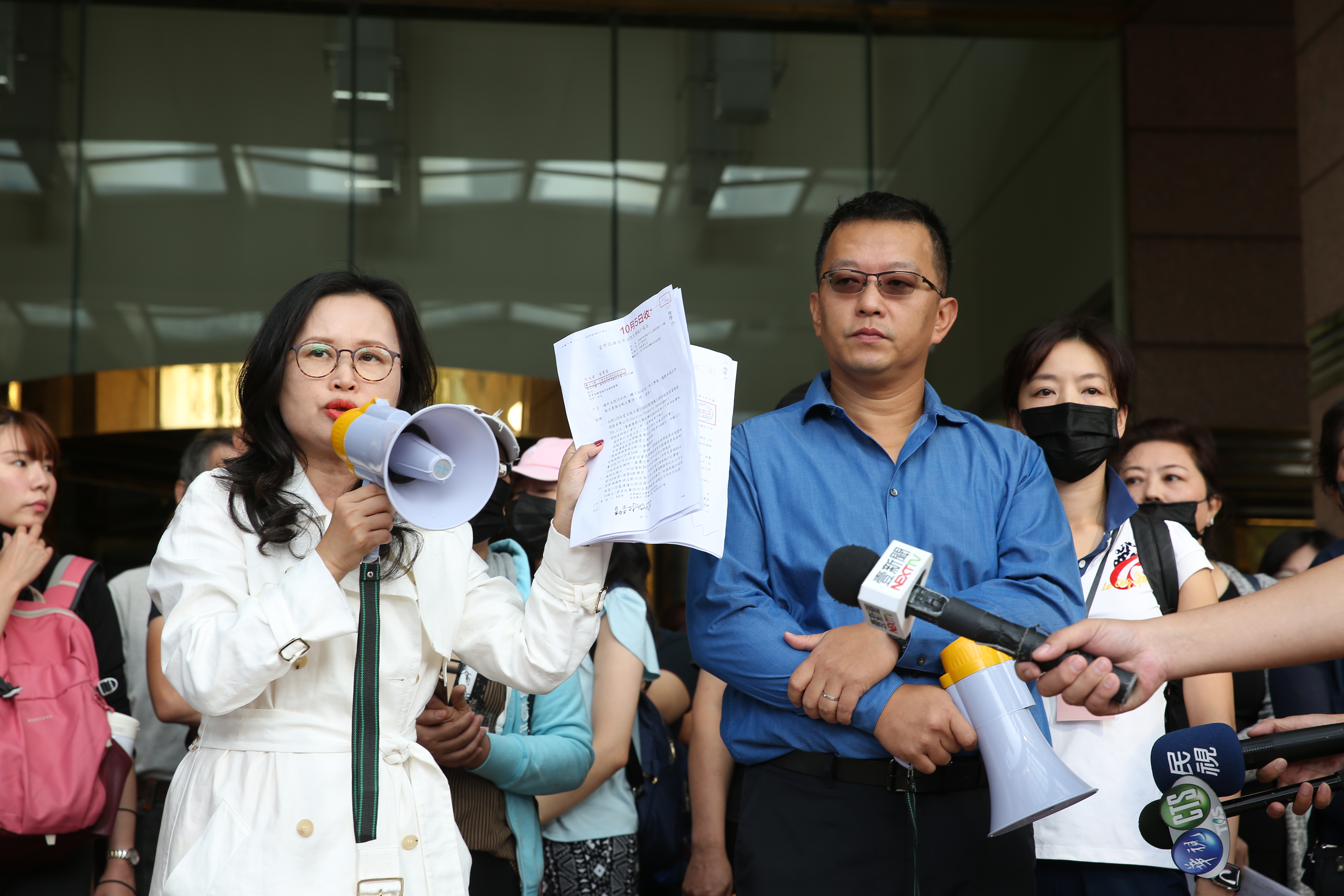 面對前君鴻員工抗議，董事長張慶輝立於層層警力後方，始終面無表情。