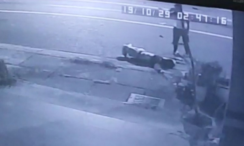 監視器拍到，穿白衣的肇事男子，下車察看男大生傷勢後打電話聯絡，接著拔腿狂奔逃離現場。（翻攝畫面）