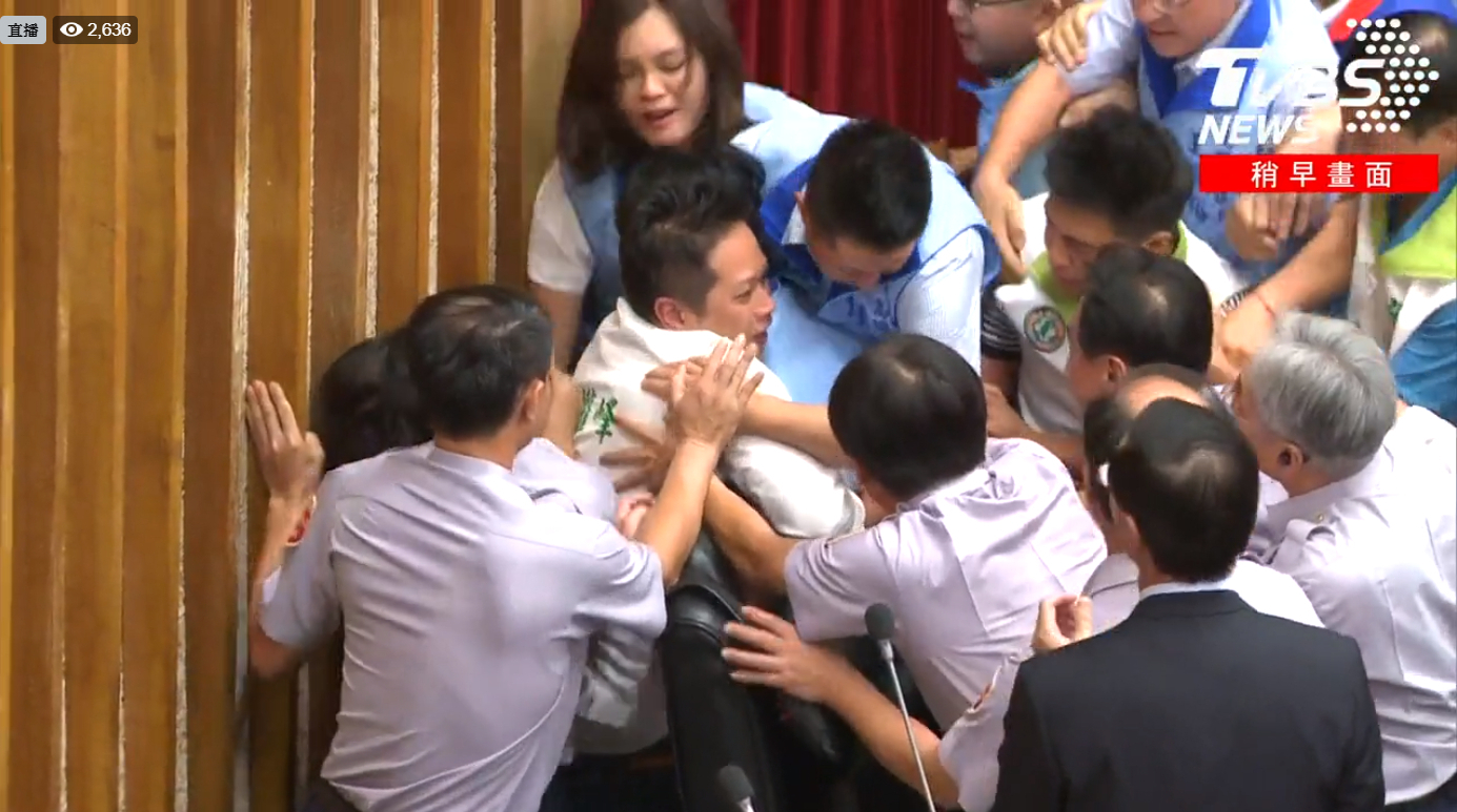 藍綠議員在市議會主席台上攻防拉扯，還導致議員眼角流血。（翻攝自TVBS新聞臉書粉絲團）