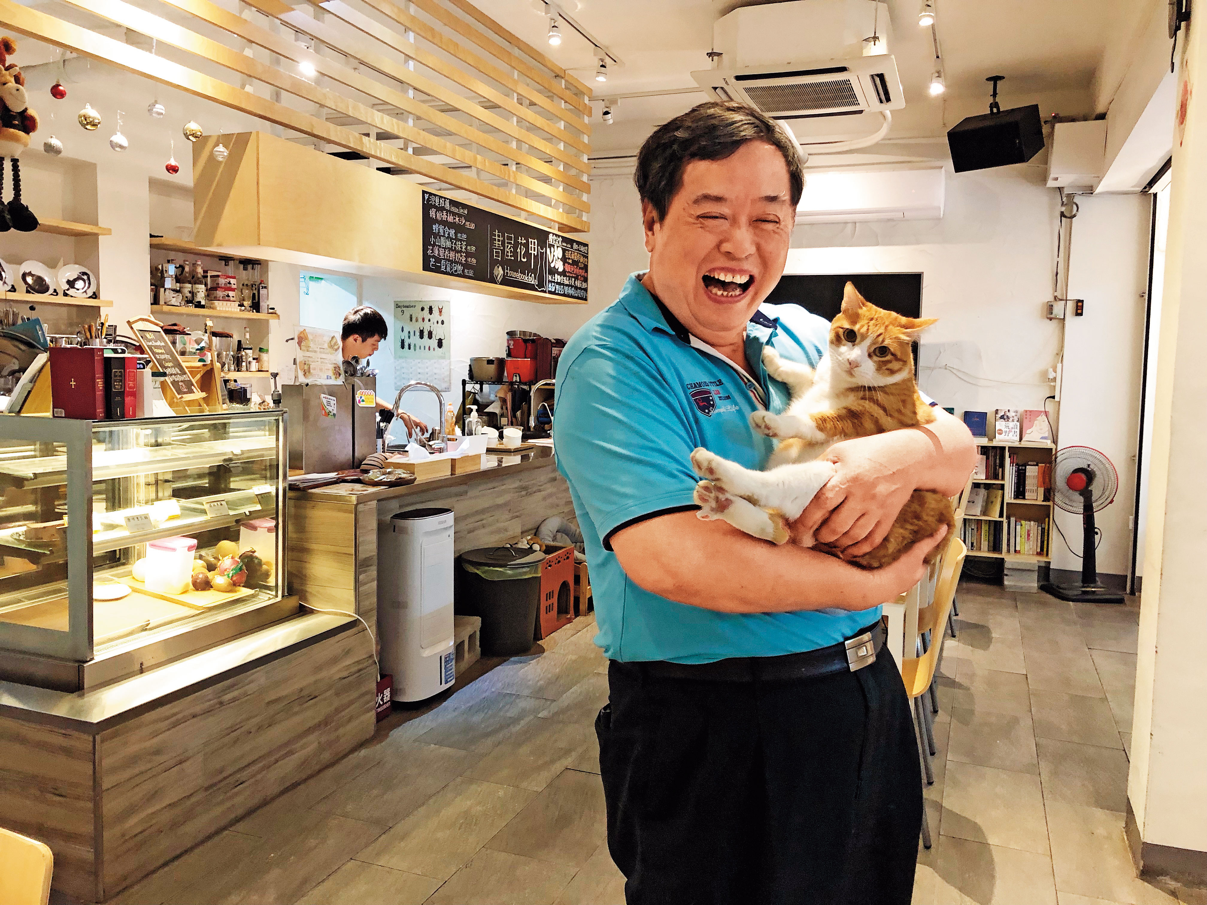 名為「書屋花甲」的咖啡店，社區青少年可在此上咖啡課程，方荷生相當疼愛店內這隻橘貓。（簡竹書攝）