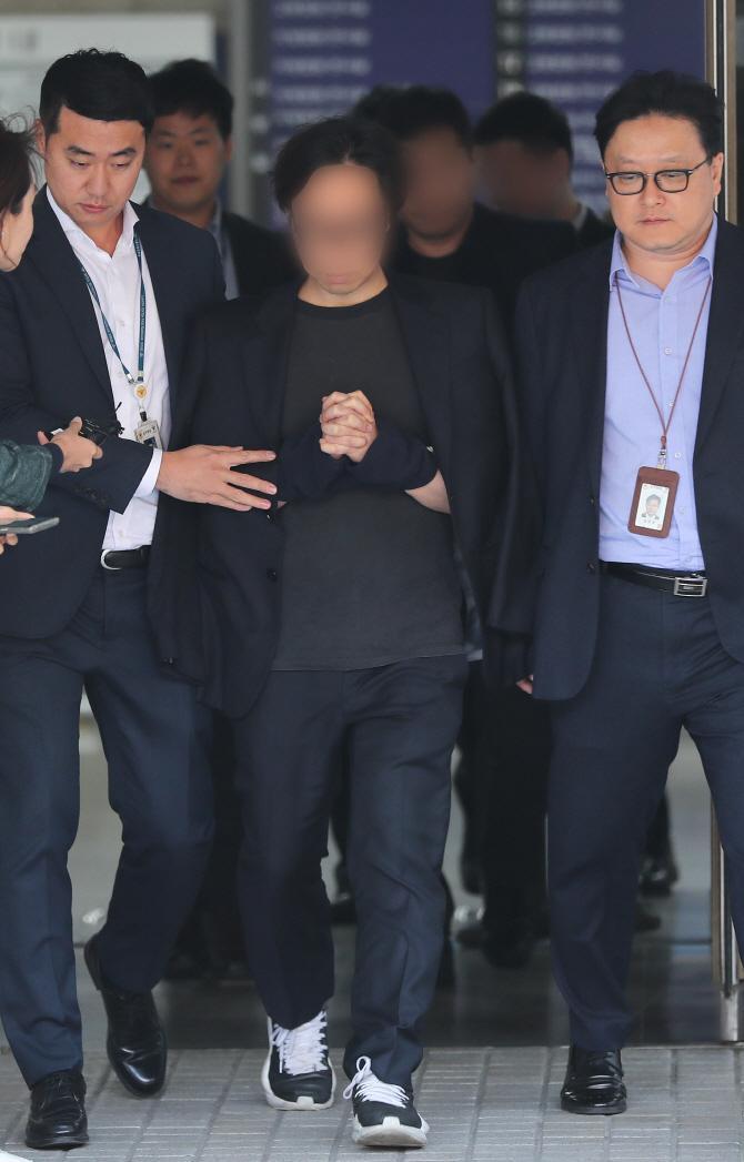 安俊英製作人在接受偵訊後,被上警繩步出法院。(網路圖片)