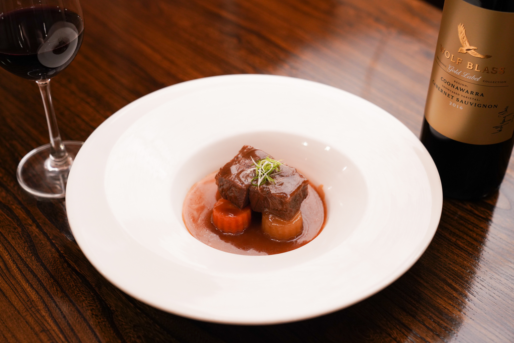禾富「金牌 庫納瓦拉 卡本內紅葡萄酒」（右，1,500元／瓶）和大三元酒樓特製的「柱侯醬和牛頰」相得益彰。（禾富酒莊提供）