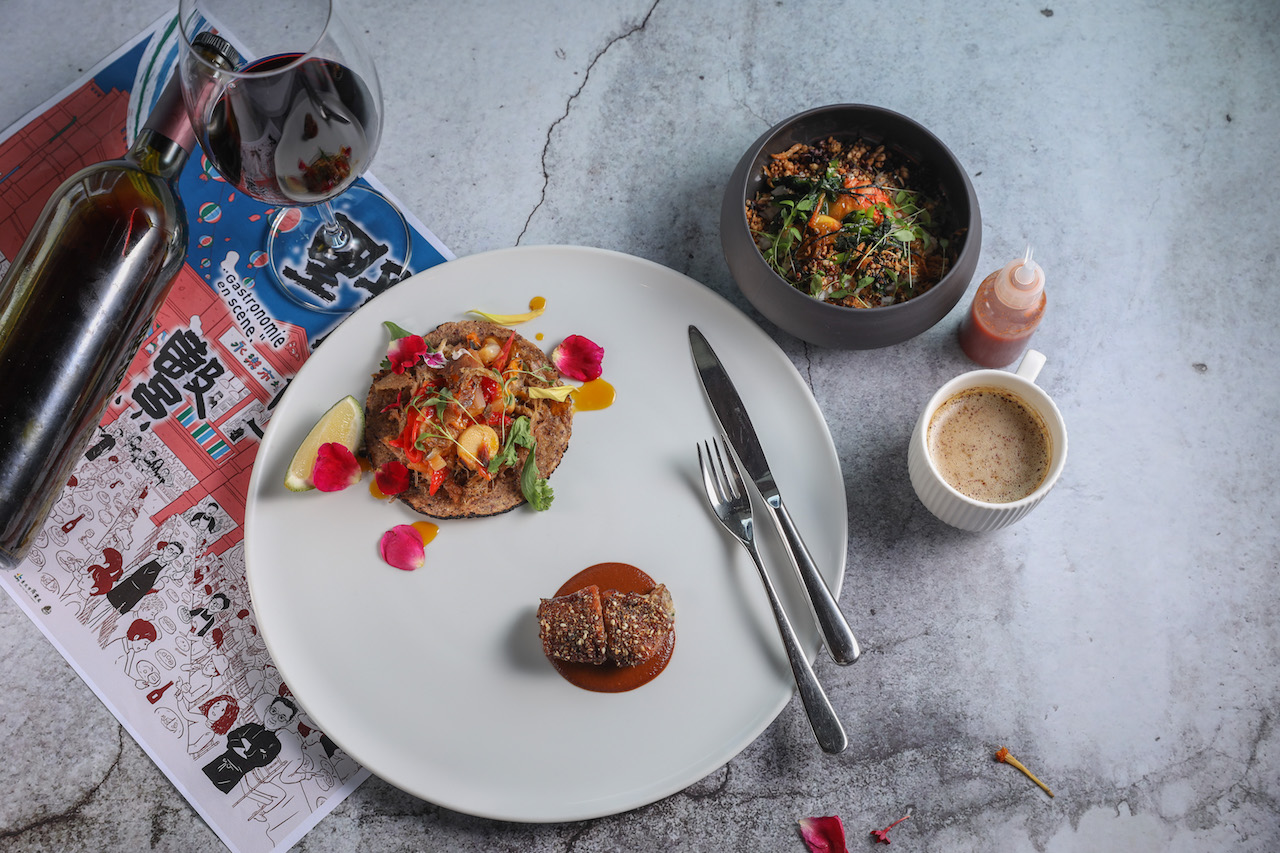 酥脆帶韌的「芳苑鴨塔可、鑲鴨翅」（下）和揉合酸甜辣味的「Gēn x Taïrroir 拌飯」（上），搭配樹生酒莊和釀酒師陳千浩聯手為餐會唯一打造的「台灣紅酒」（左）或「薄暮。鹹咖啡」（右），餐會走到這裡會進入主旋律，清晰合諧。（8,800元套餐菜色）