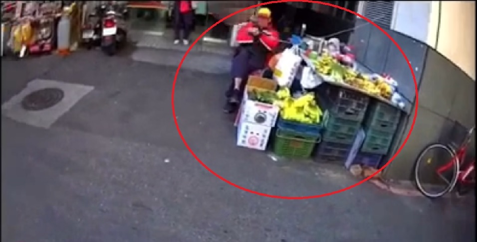 警勸不聽要沒入攤駕時,蘇翁竟拿鐮刀追砍,李員用辣椒水制止。(翻攝畫面)