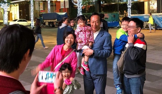 鴻海集團創辦人郭台銘吃完晚餐後現身信義區，熱情粉絲搶合照。（翻攝郭台銘粉絲團）