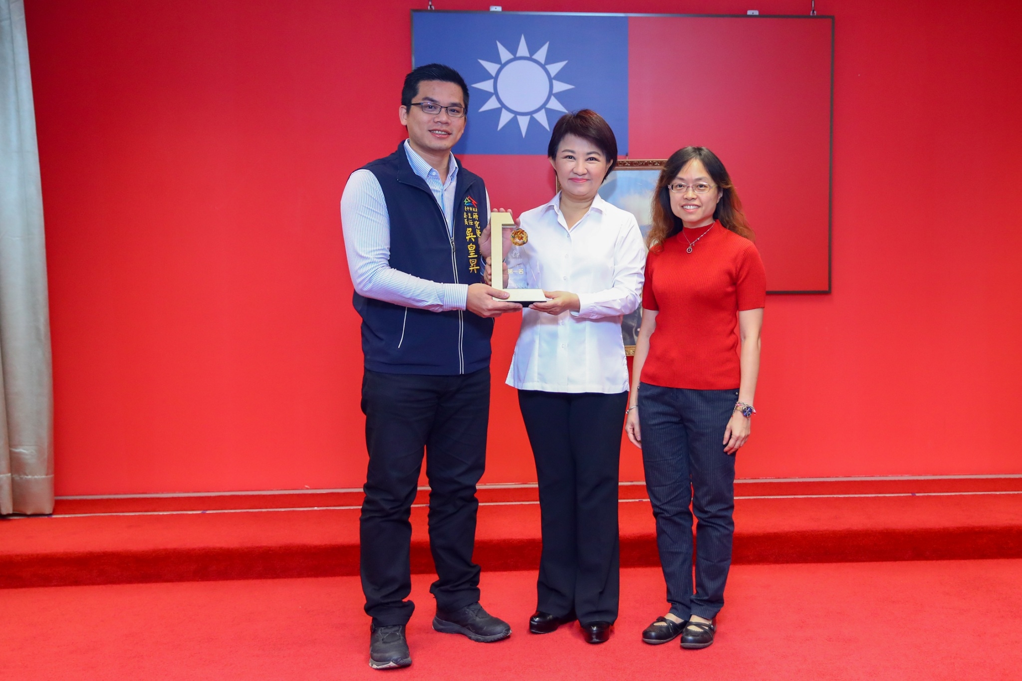 台中市政府榮獲108年政府開放資料金質獎第一名，由台中市府研考會主委吳皇昇於市政會議進行獻給台中市長盧秀燕，將奪金的榮耀歸功於台中市民。（台中市政府提供）