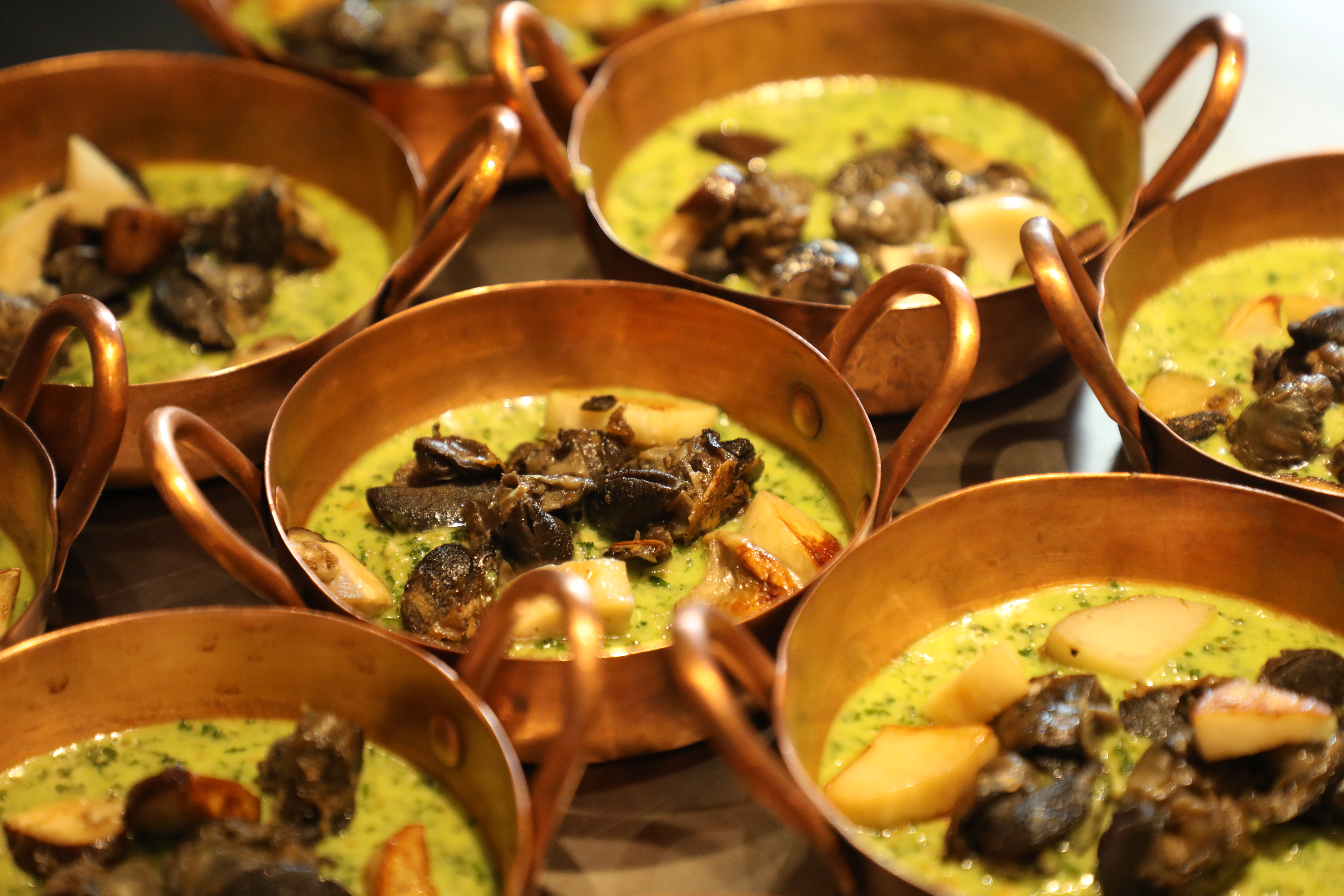 「香菇田螺佐荷蘭芹醬」用28年資歷的小銅鍋在鐵板上烹調，復古懷舊。（1,980元起套餐菜色）