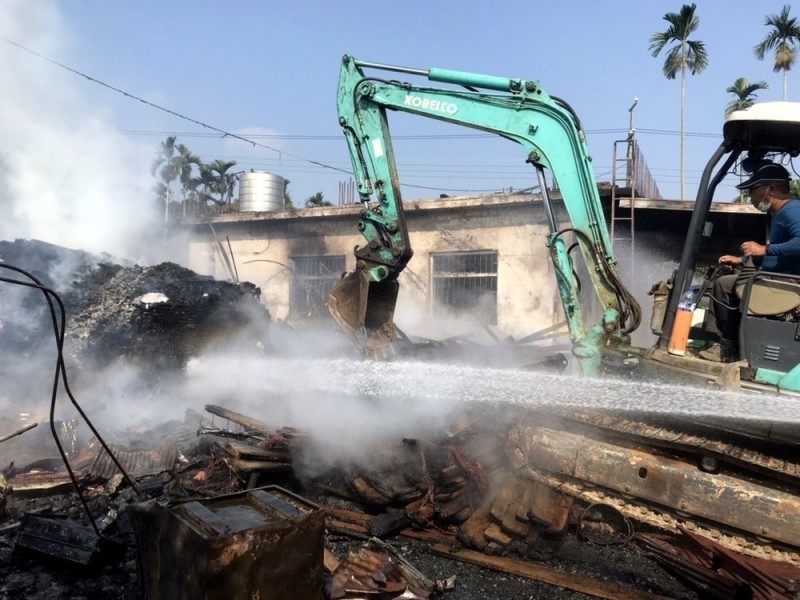 南投發生1起工寮火警，挖土機也加入滅火行列，協助搬走廠內機具。（翻攝畫面）