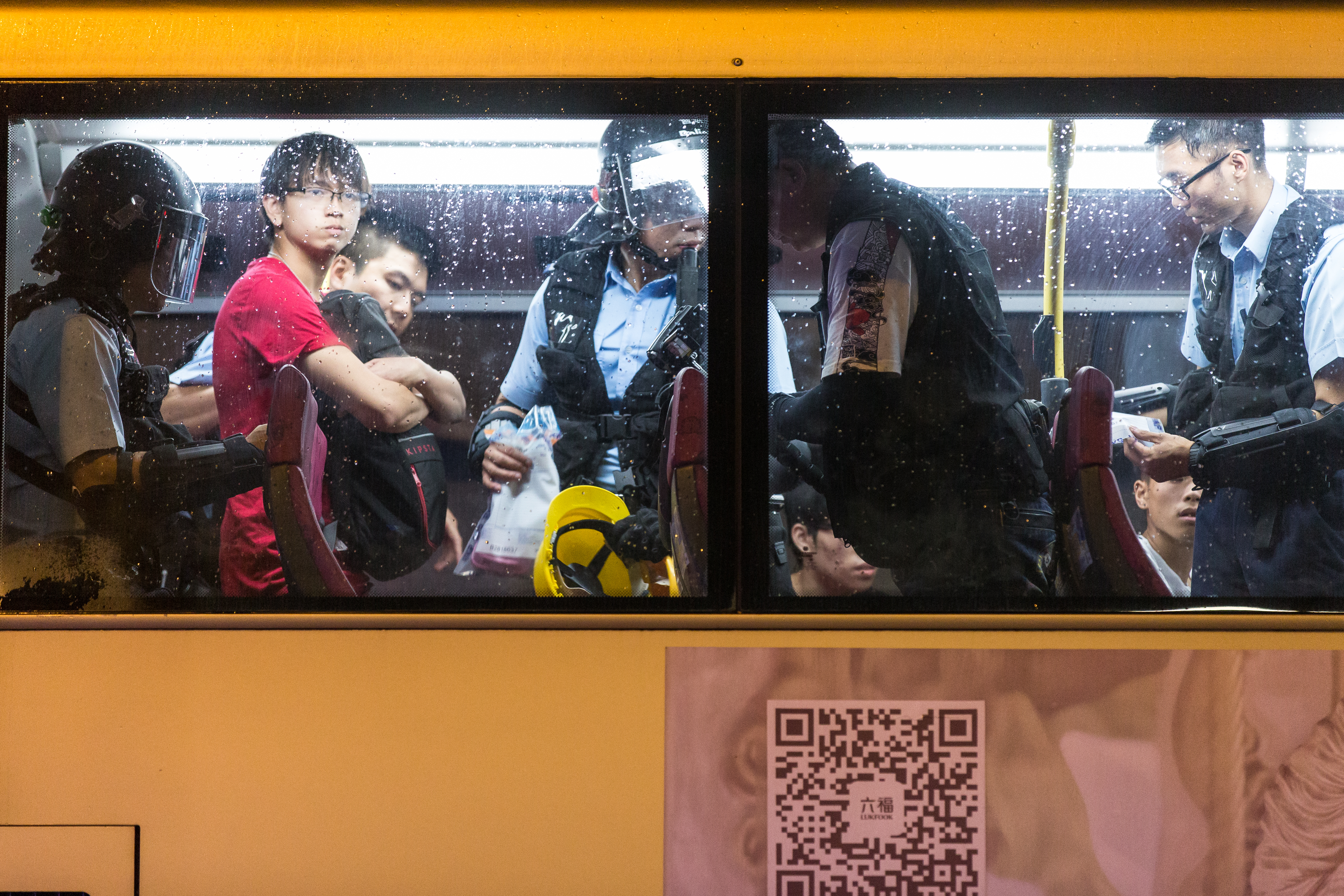 港警隨機至巴士上逐一盤查民眾，翻閱隨身物品。（本刊資料照）